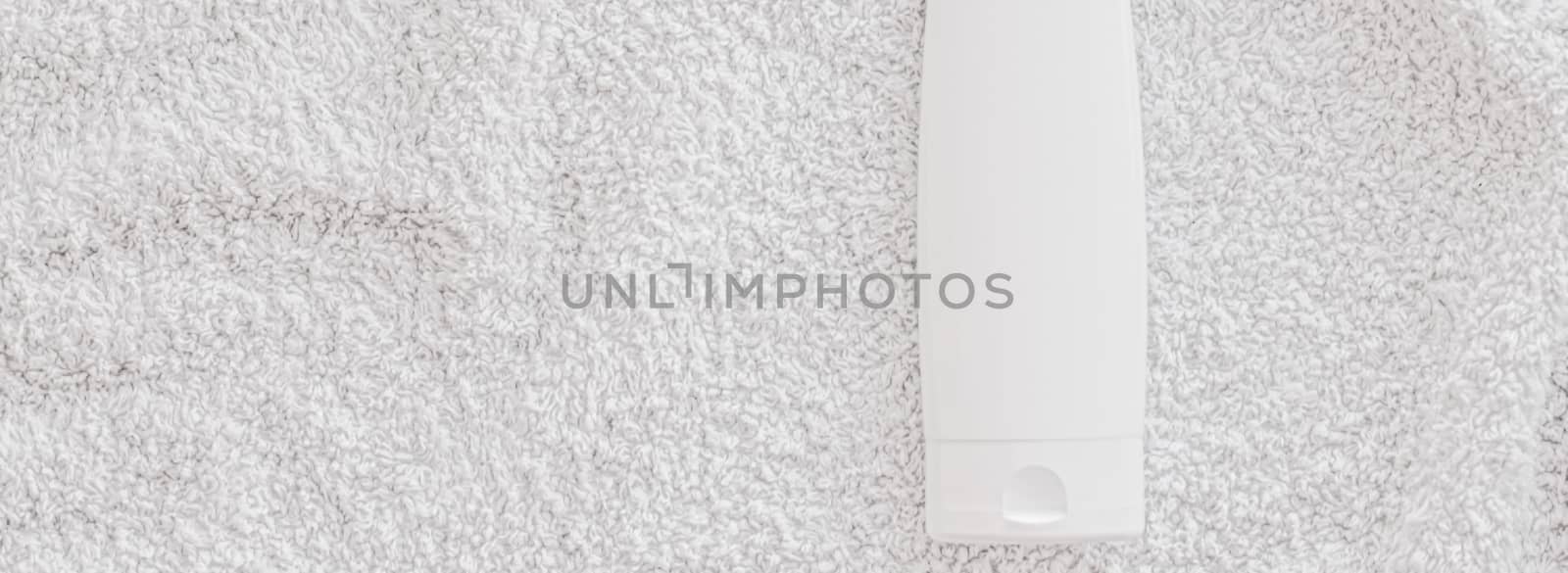 Blank label cosmetic container bottle as product mockup on white towel background, hygiene and healthcare