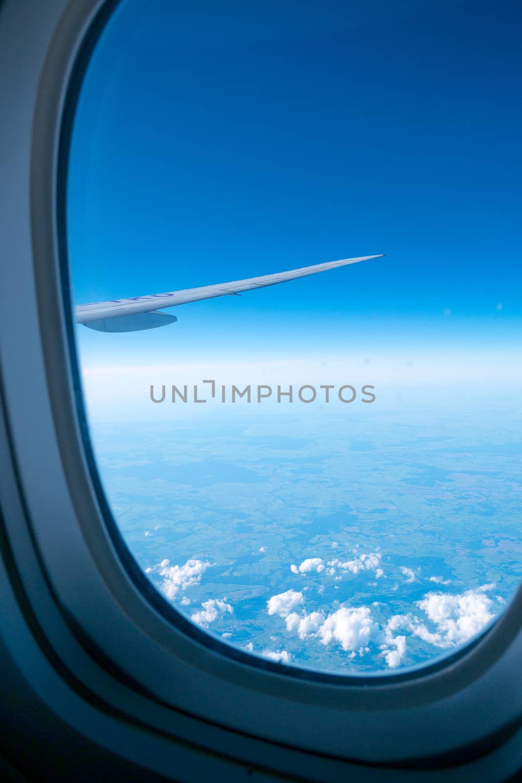 Clouds and sky sunny day through airplane window by Alicephoto