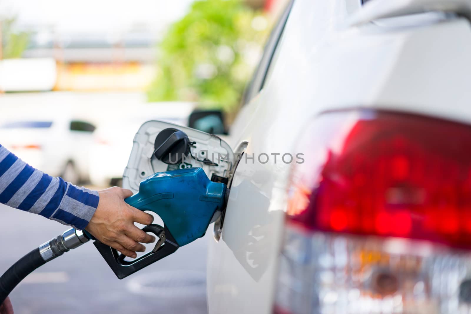 Refill fuel to a car at gas station by Alicephoto