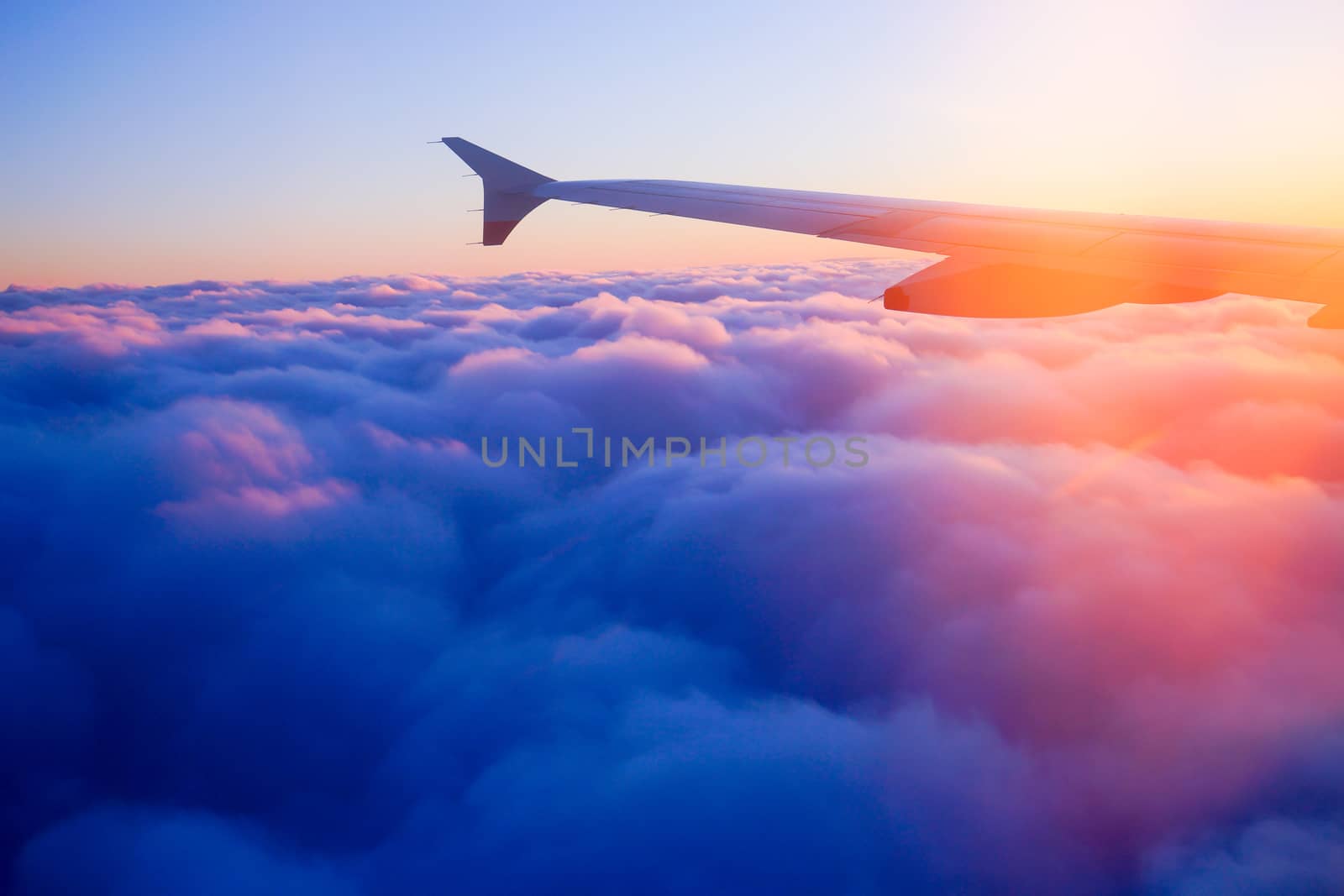 Airplane Wing in Flight from window, sunset sky by Alicephoto