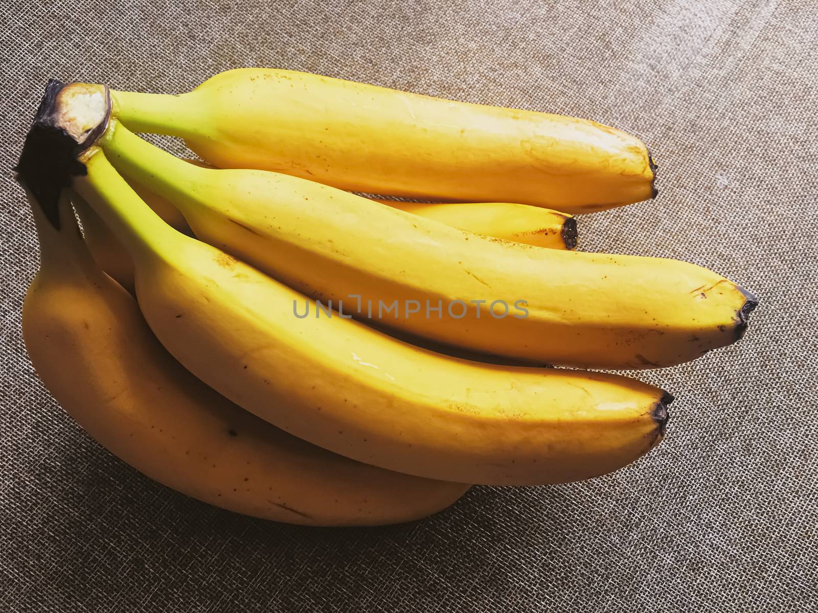 Organic bananas on rustic linen background by Anneleven