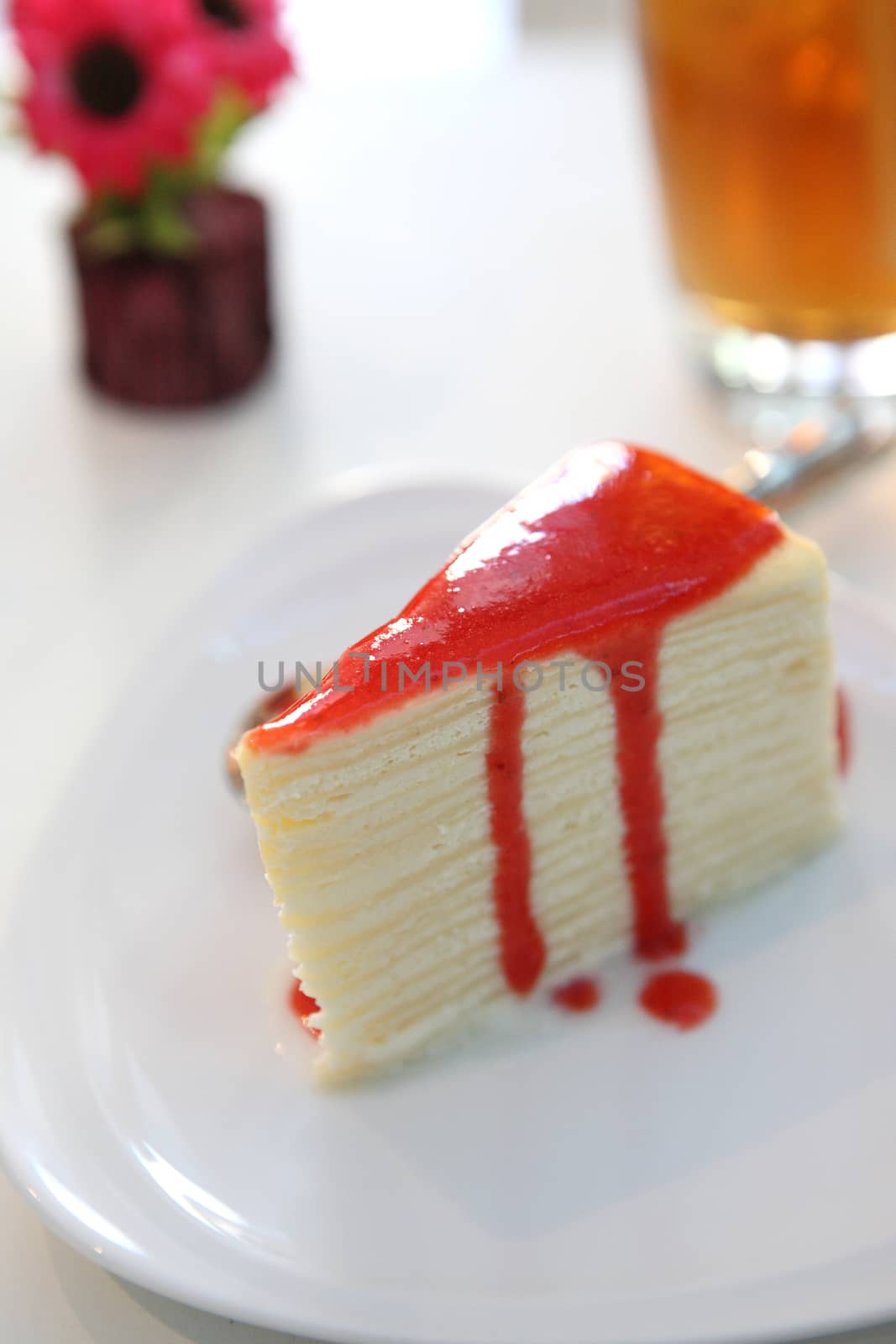 Crape cake pour with strawberry sauce on plate 