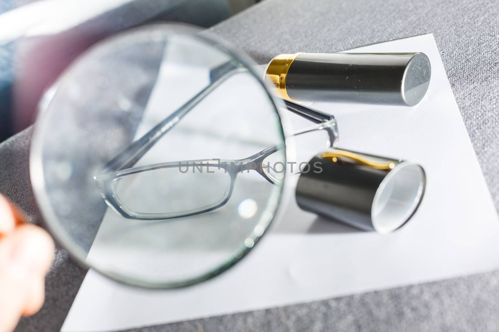 magnifier and glasses on a sheet of paper for business behind blind