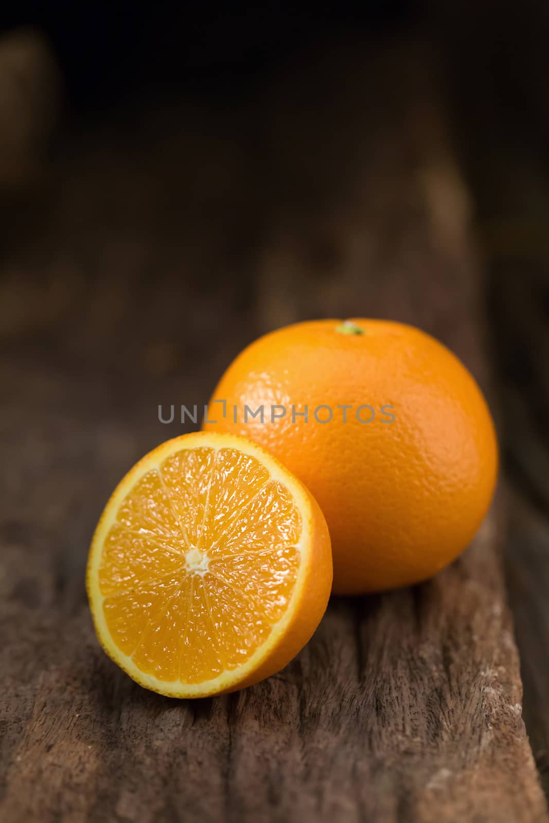fresh orange and orange slices group on a dark wooden table.