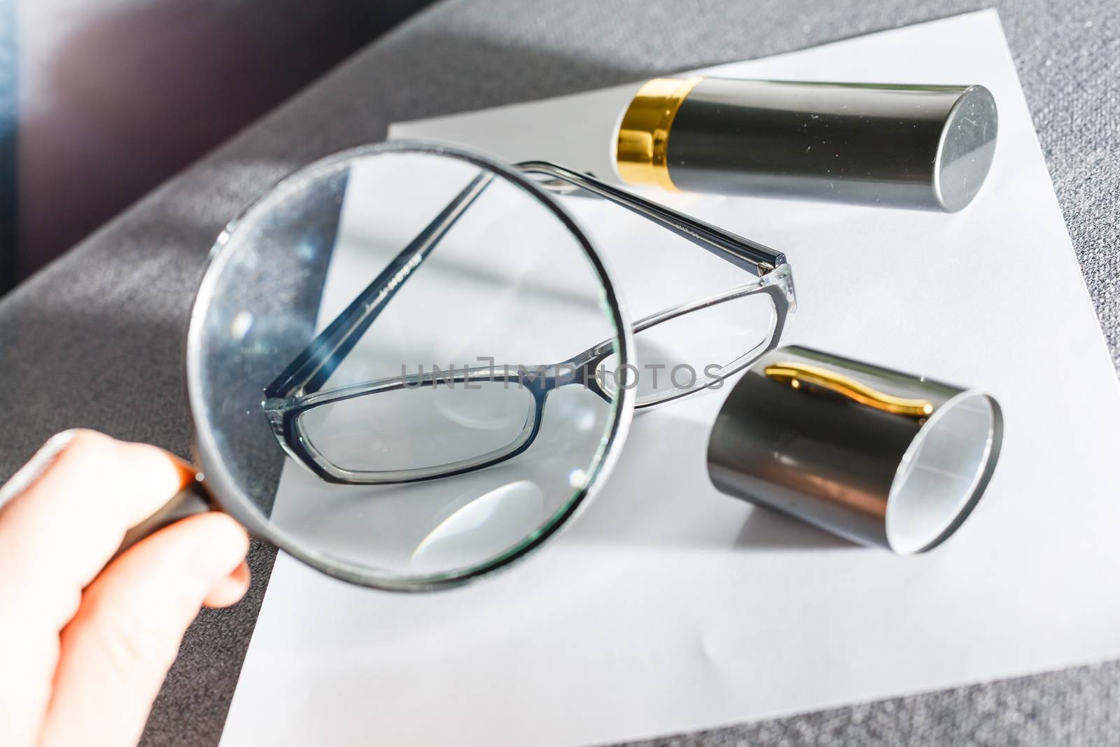 magnifier and glasses on a sheet of paper for business behind blind