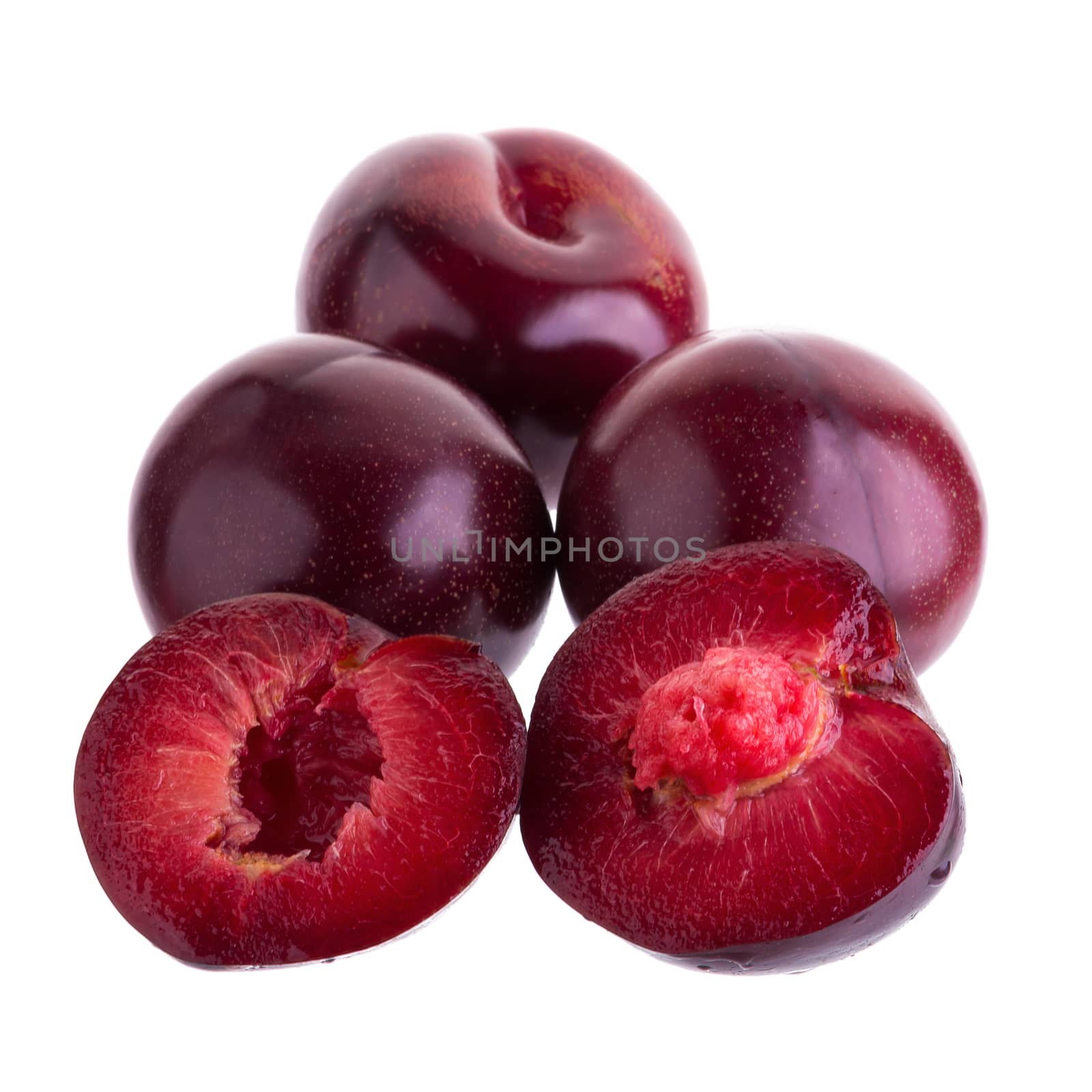 ripe fresh plum with half and slice isolated on white background by kaiskynet