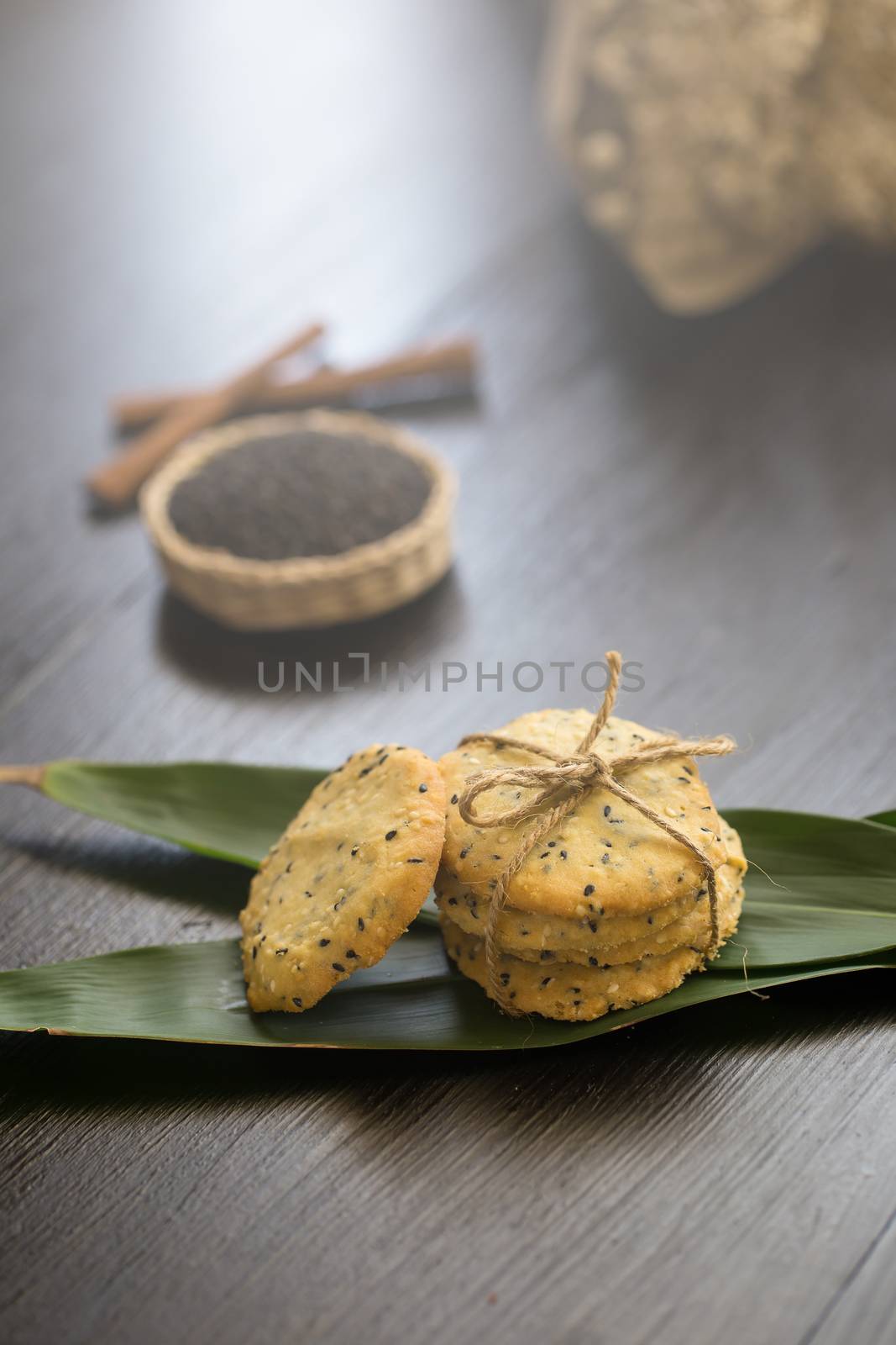 Sesame Cookies, sesame and milk on black wooden background.