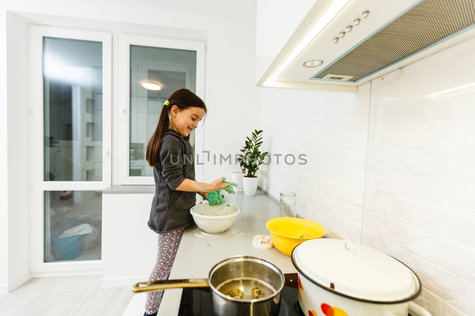 Little cute girl is cooking on kitchen. Having fun while making cakes and cookies