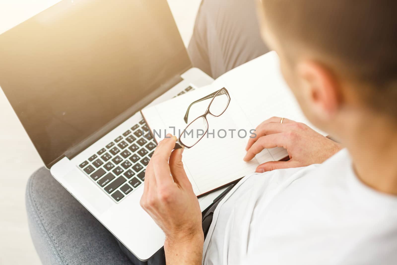 Young man working absorbed on laptop at home copy space