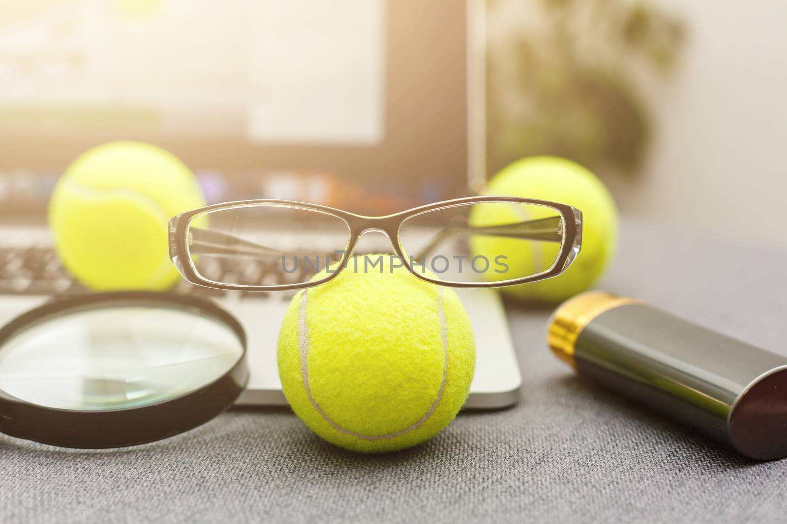 Top view of laptop, Sports Equipment, Tennis ball, glasses on the Sports administration white table.Business concept.