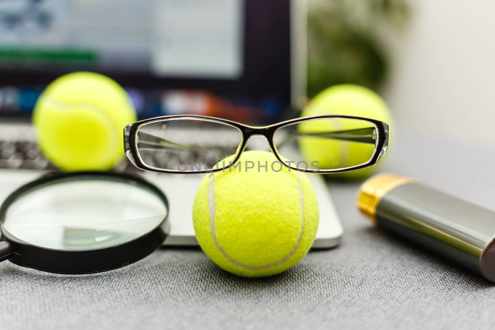 Top view of laptop, Sports Equipment, Tennis ball, glasses on the Sports administration white table.Business concept.