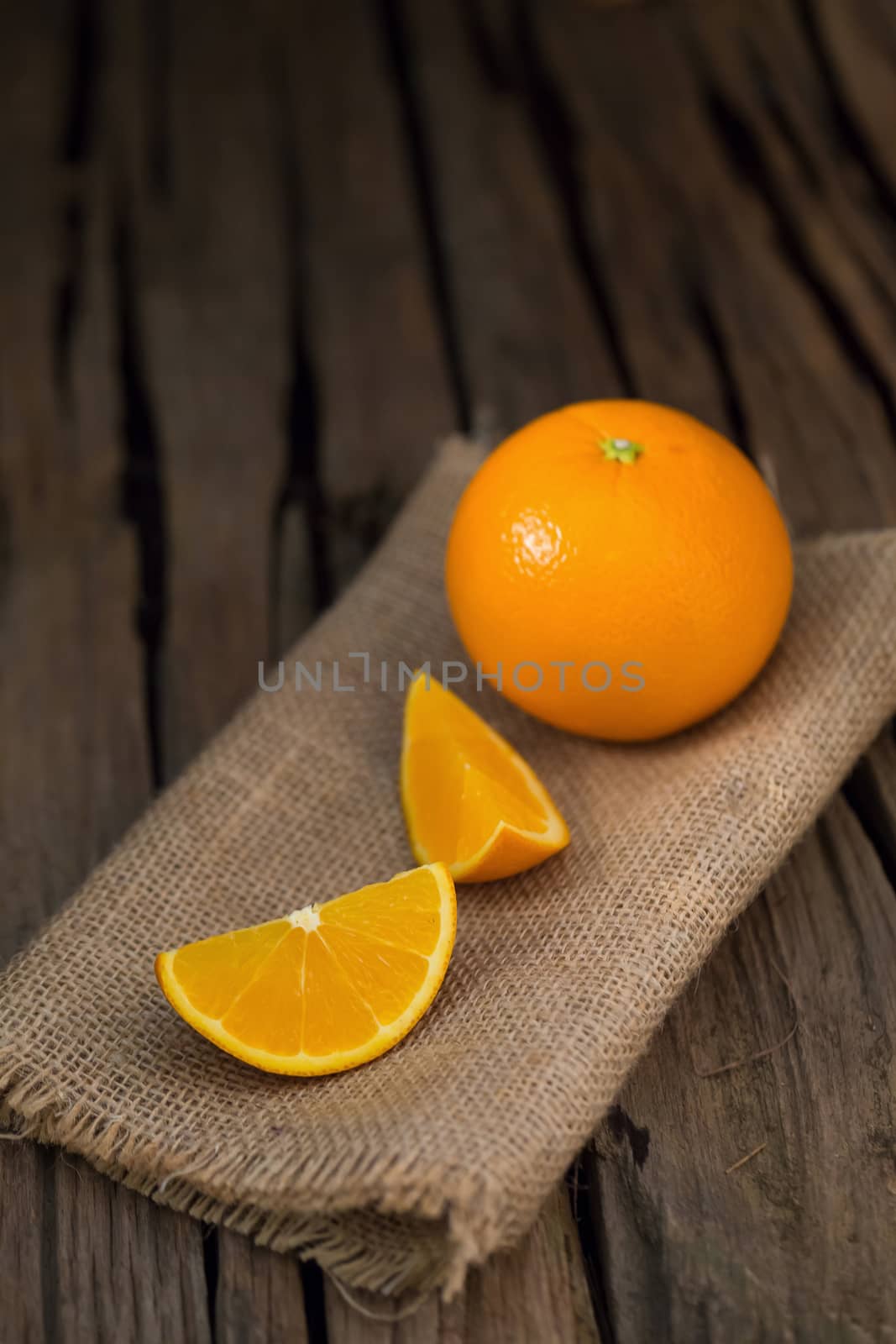 fresh orange and orange slices group on a dark wooden table by kaiskynet