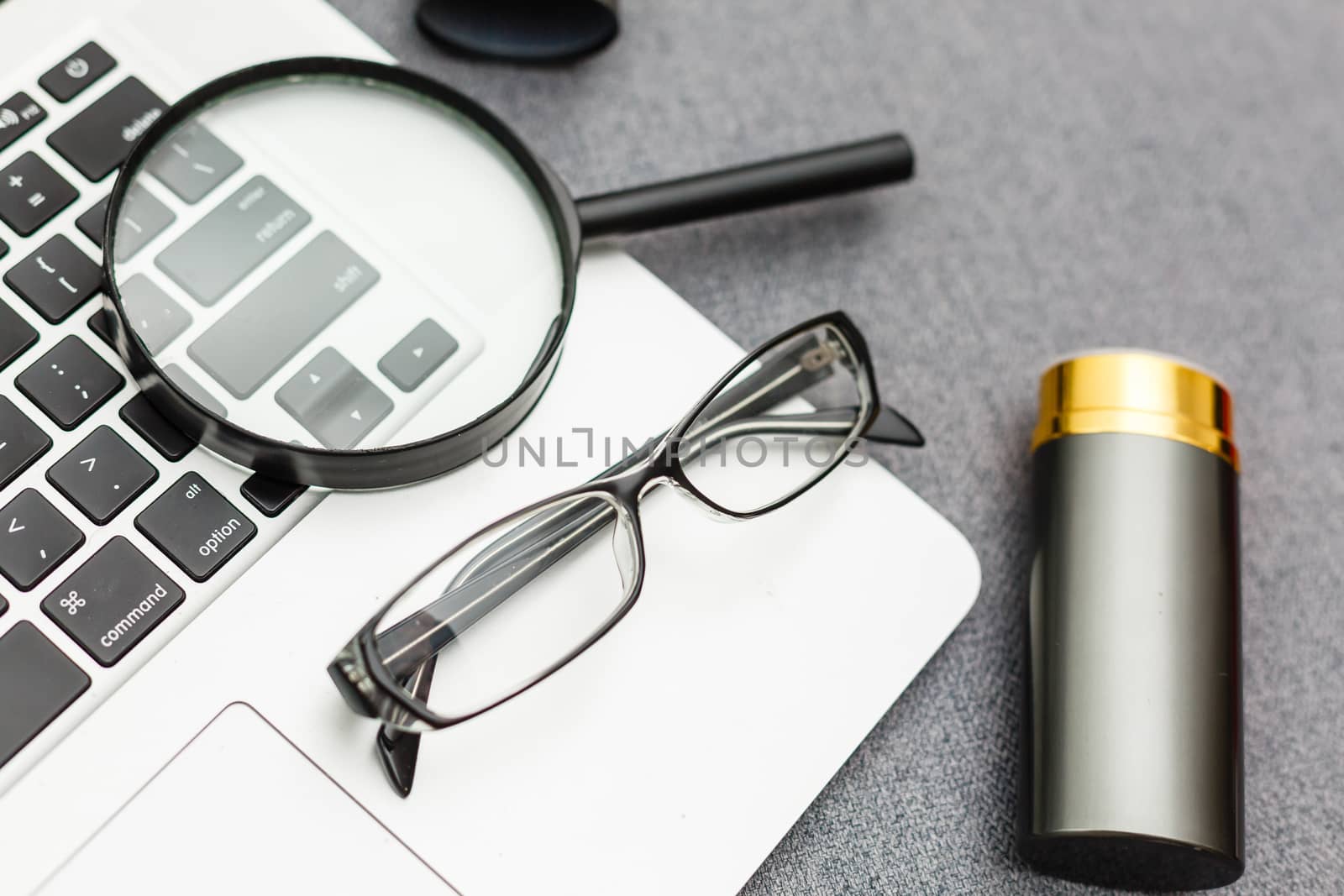 Business summary reports and a magnifying glass with glasses on table office. Concept of Data Analysis, Investment Planning, Business Analytics.