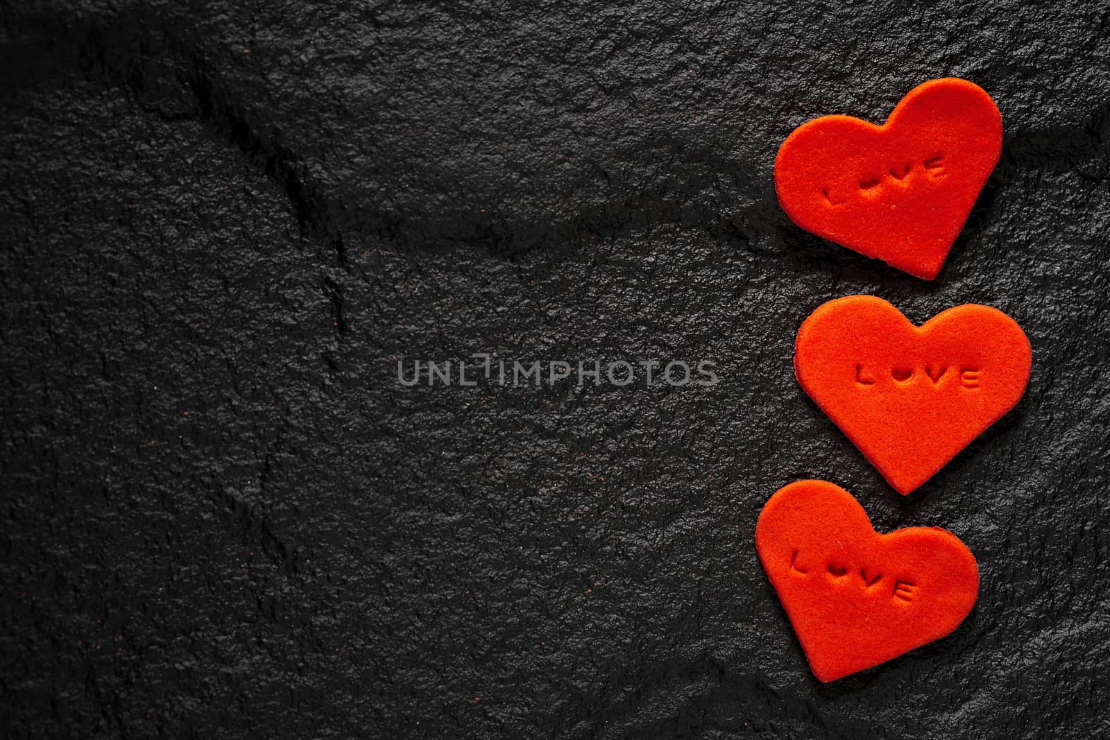 Red heart written love words placed on black stone floor by kaiskynet