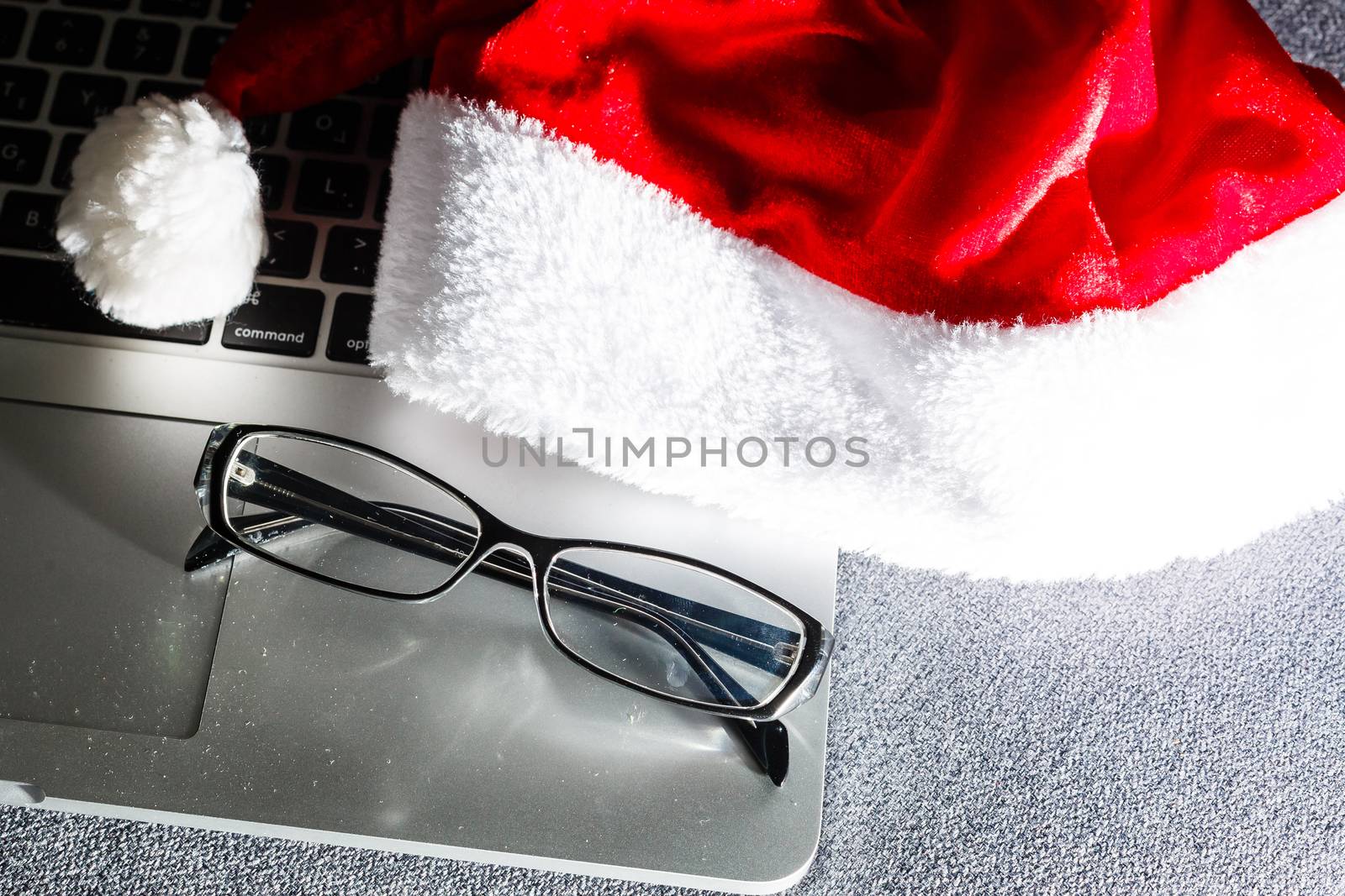 laptop keyboard. Work on the eve of the New Year. Top view, laptop keyboard, Santa hat, present