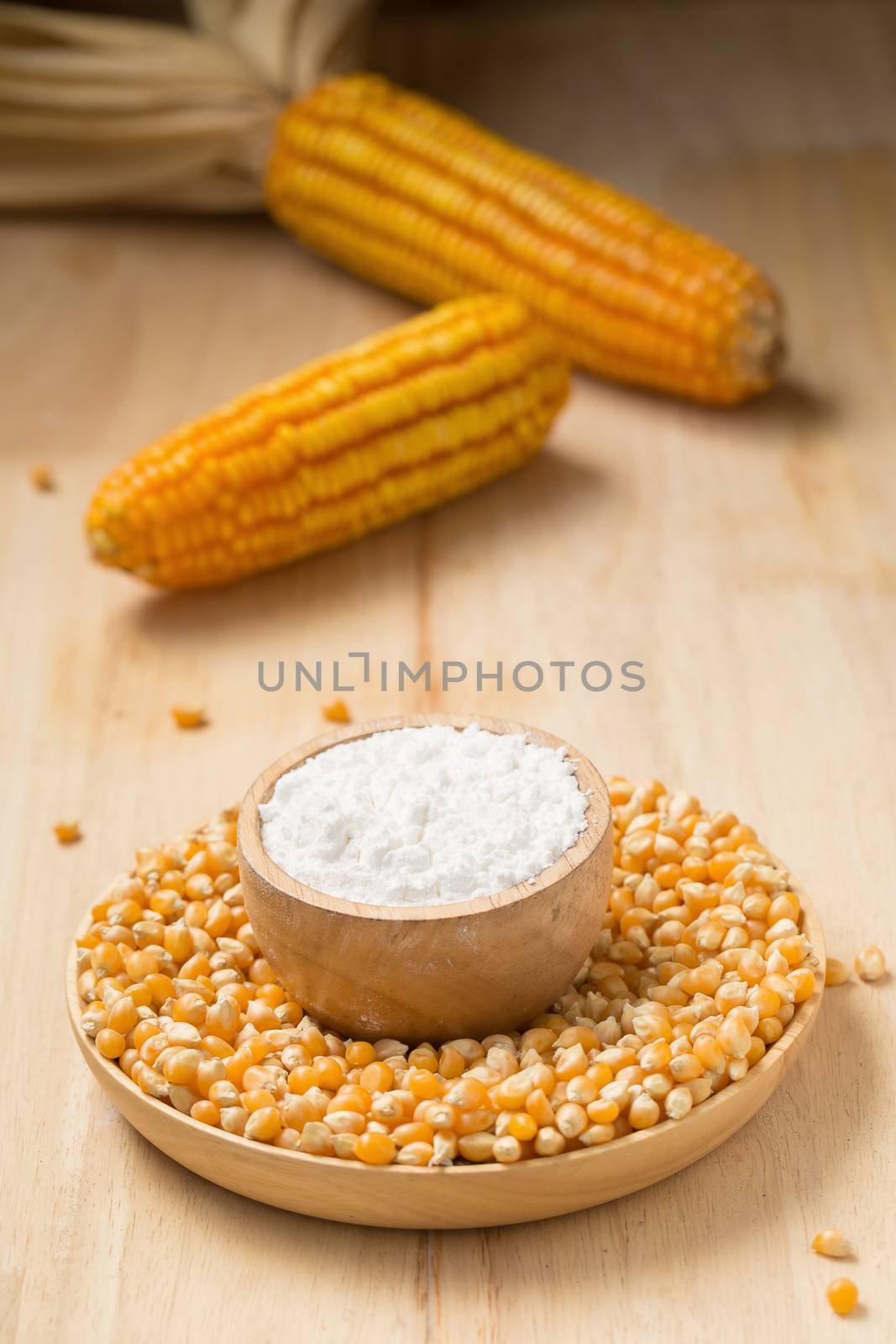 Corn flour in a bowl over a wooden table by kaiskynet