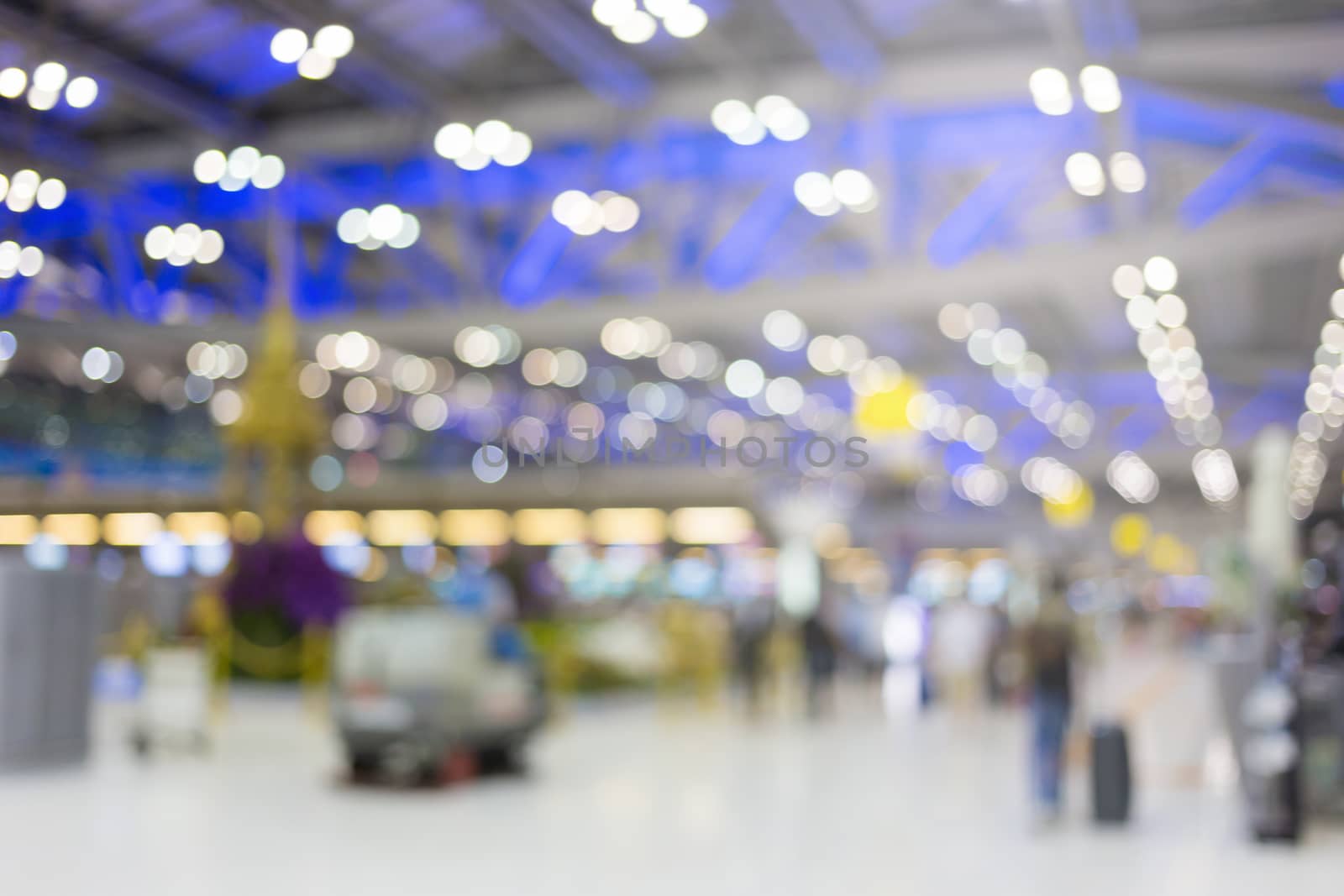 blurred image of travelers smart people walking with a luggag at airport terminal with crowd of travelling people in background. Traveling concept.