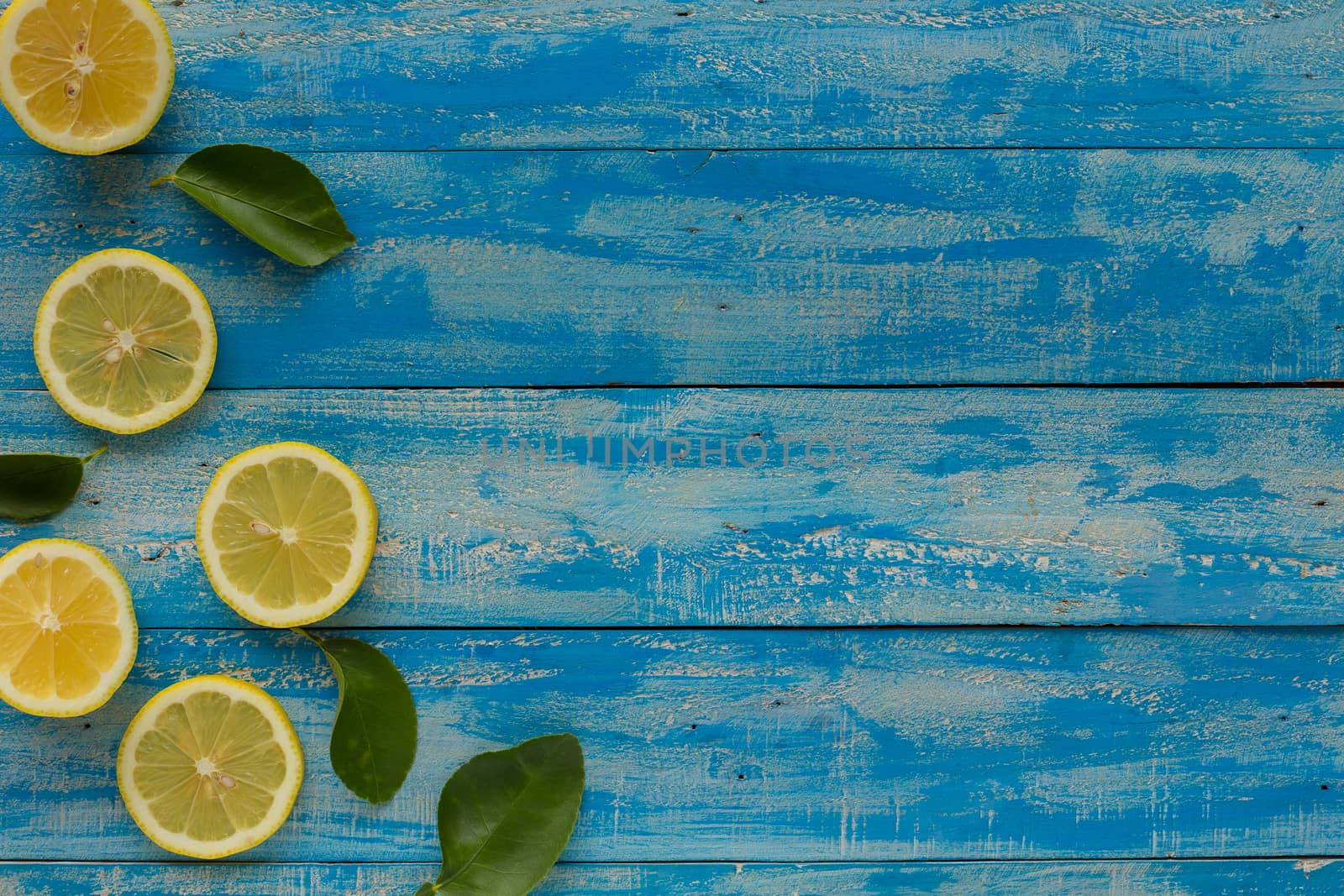 Yellow lemon on a blue wooden background. Top view.