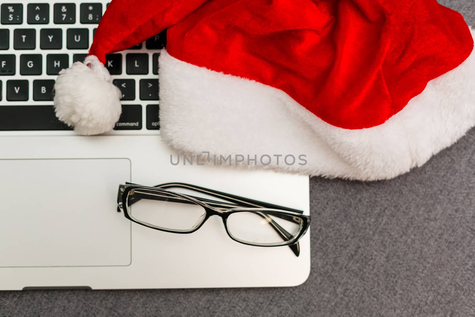 laptop keyboard. Work on the eve of the New Year. Top view, laptop keyboard, Santa hat, present