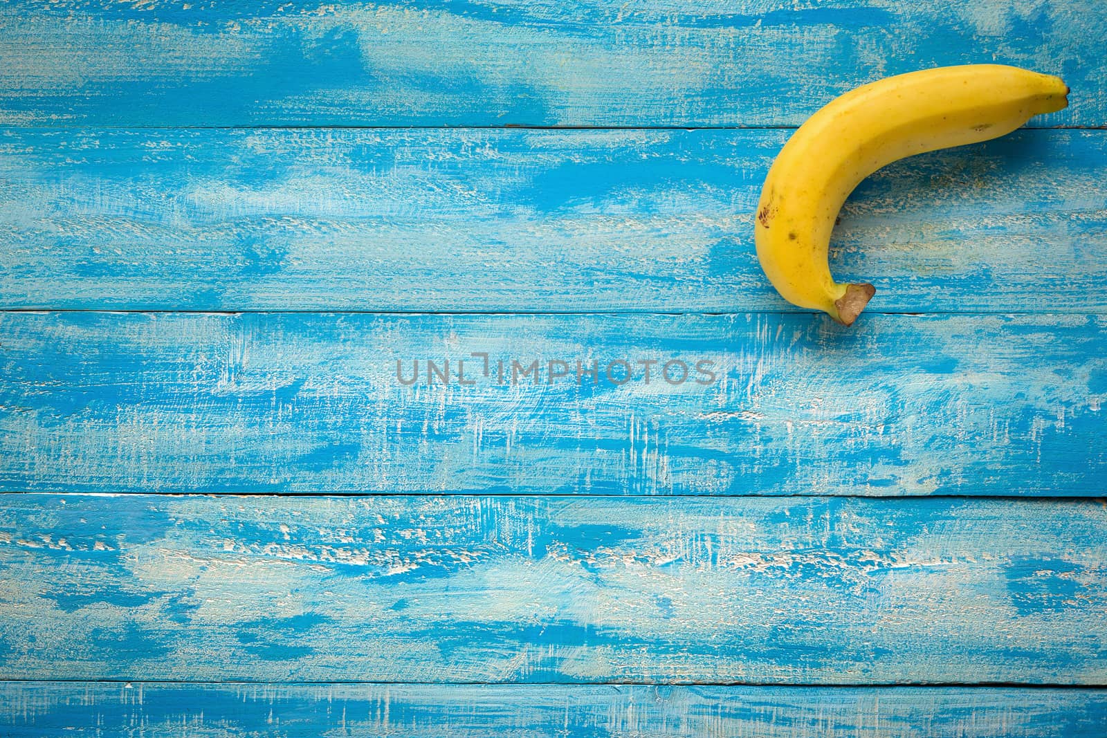 Ripe Bananas on a blue wooden table top view.