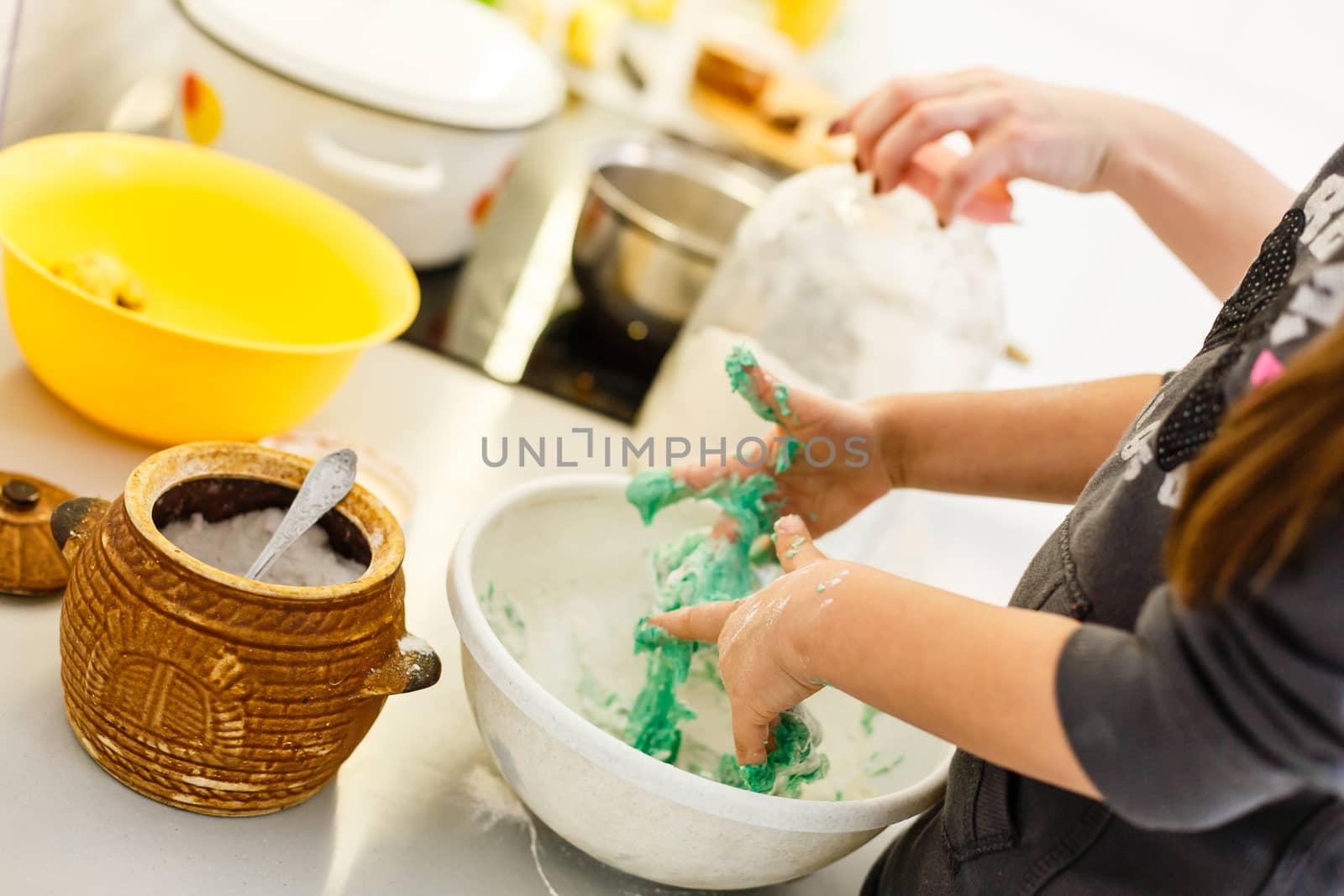 Little cute girl is cooking on kitchen. Having fun while making cakes and cookies. Smiling