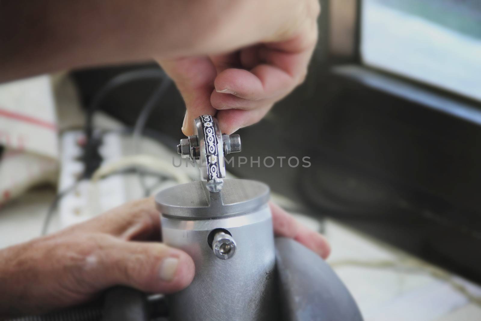 Jeweler mints silver decoration in workshop by destillat