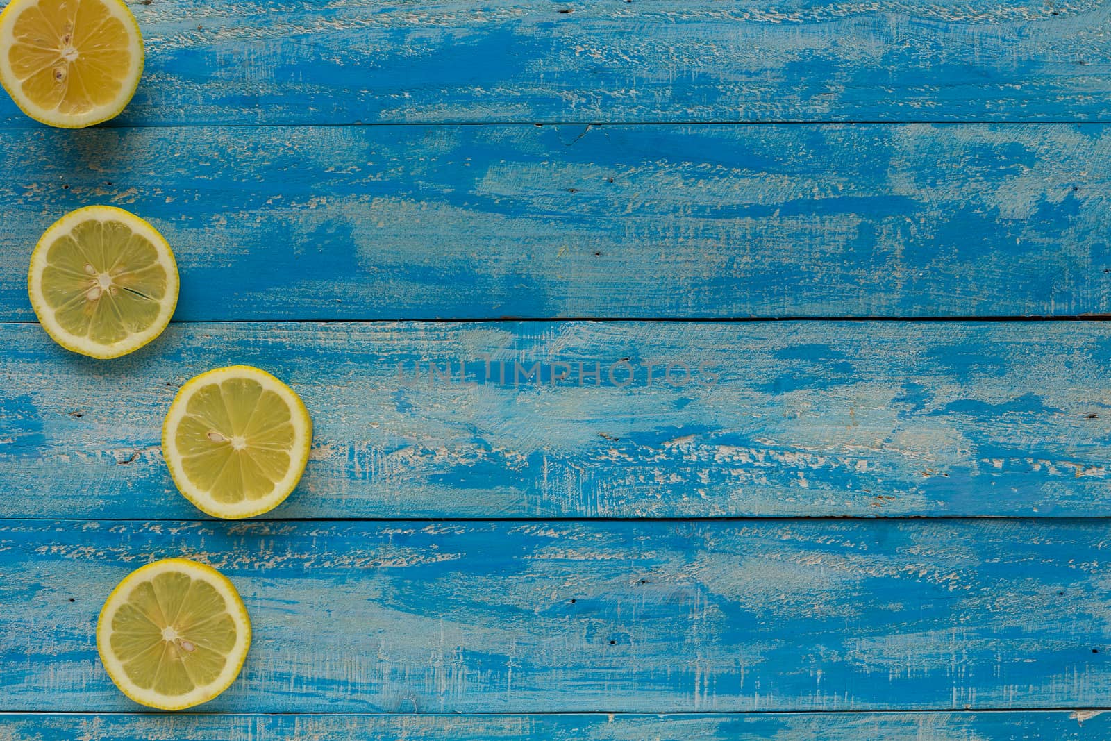 Yellow lemon on a blue wooden background. Top view.