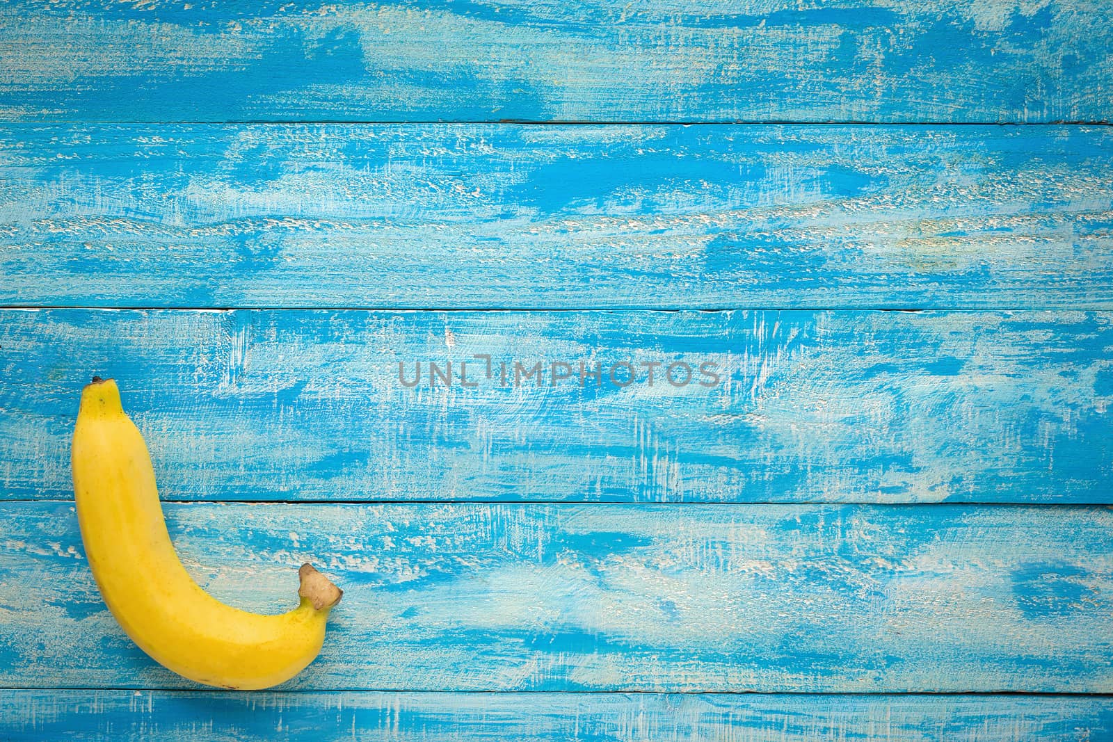 Ripe Bananas on a blue wooden table top view by kaiskynet