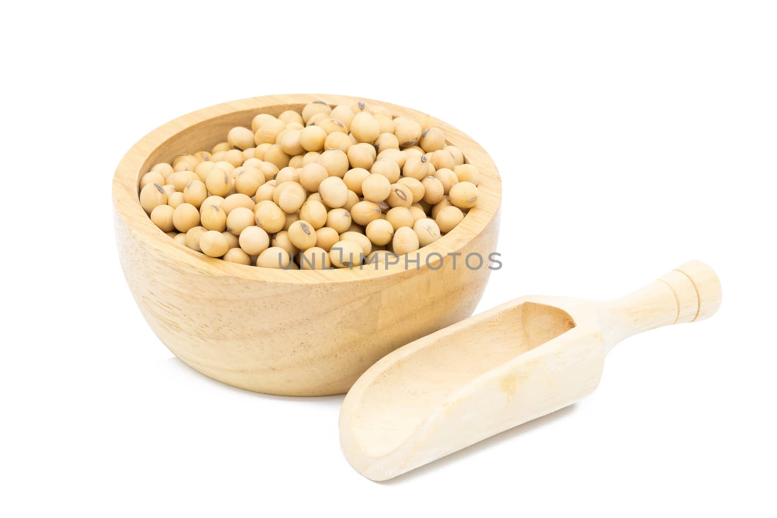 Soybeans in a wooden bowl with wooden spoon on a white background.