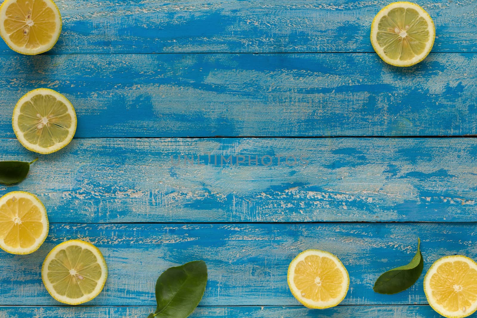 Yellow lemon on a blue wooden background. Top view by kaiskynet