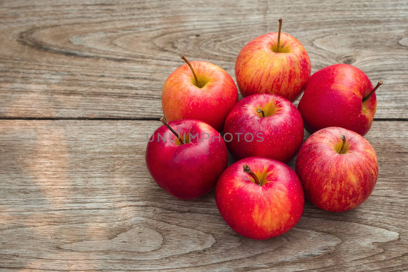 Red apples on a wooden table background.
