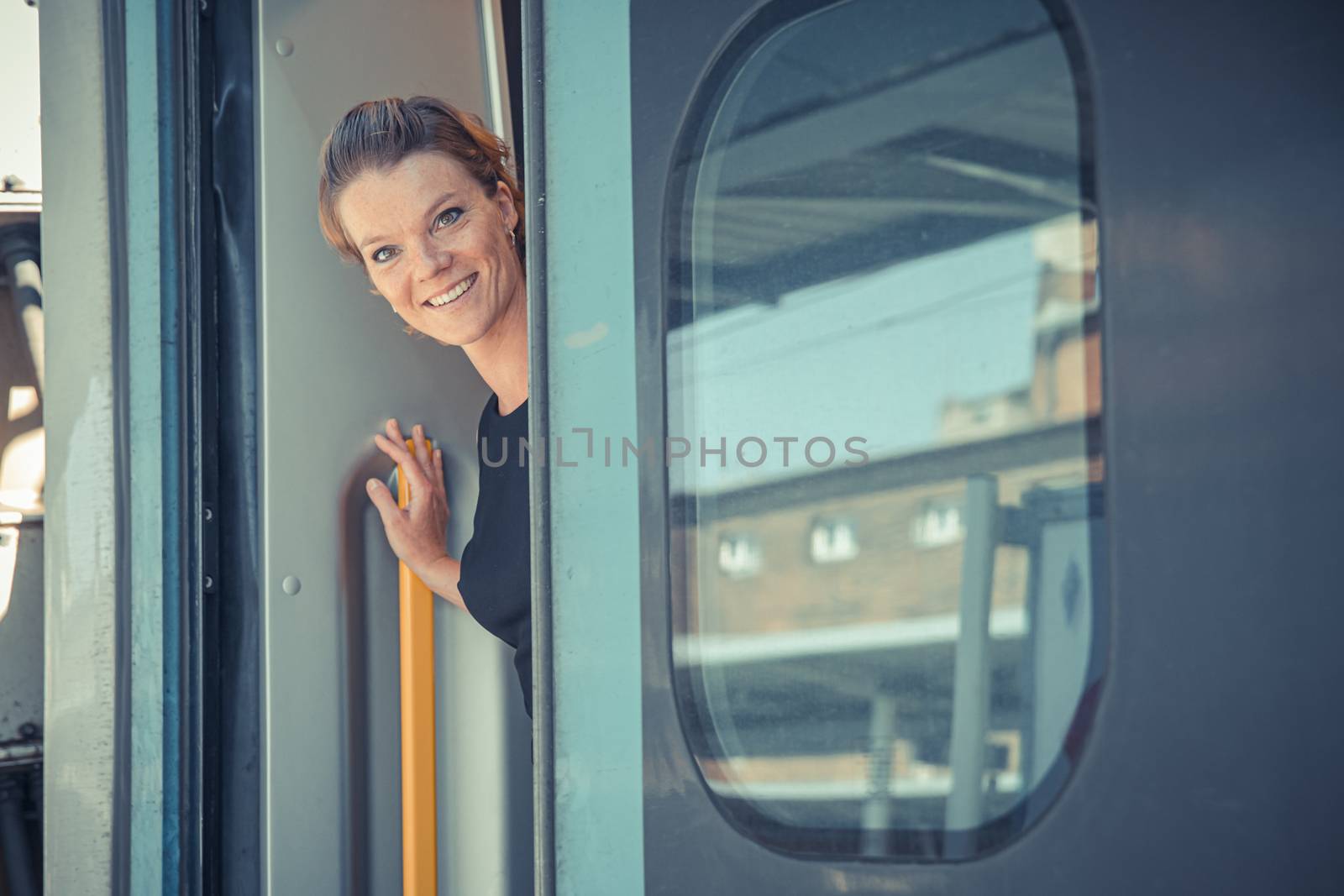 Young attractive woman bussinessman says goodbye to a boarder on train train. He enters the international train with his luggage by Edophoto