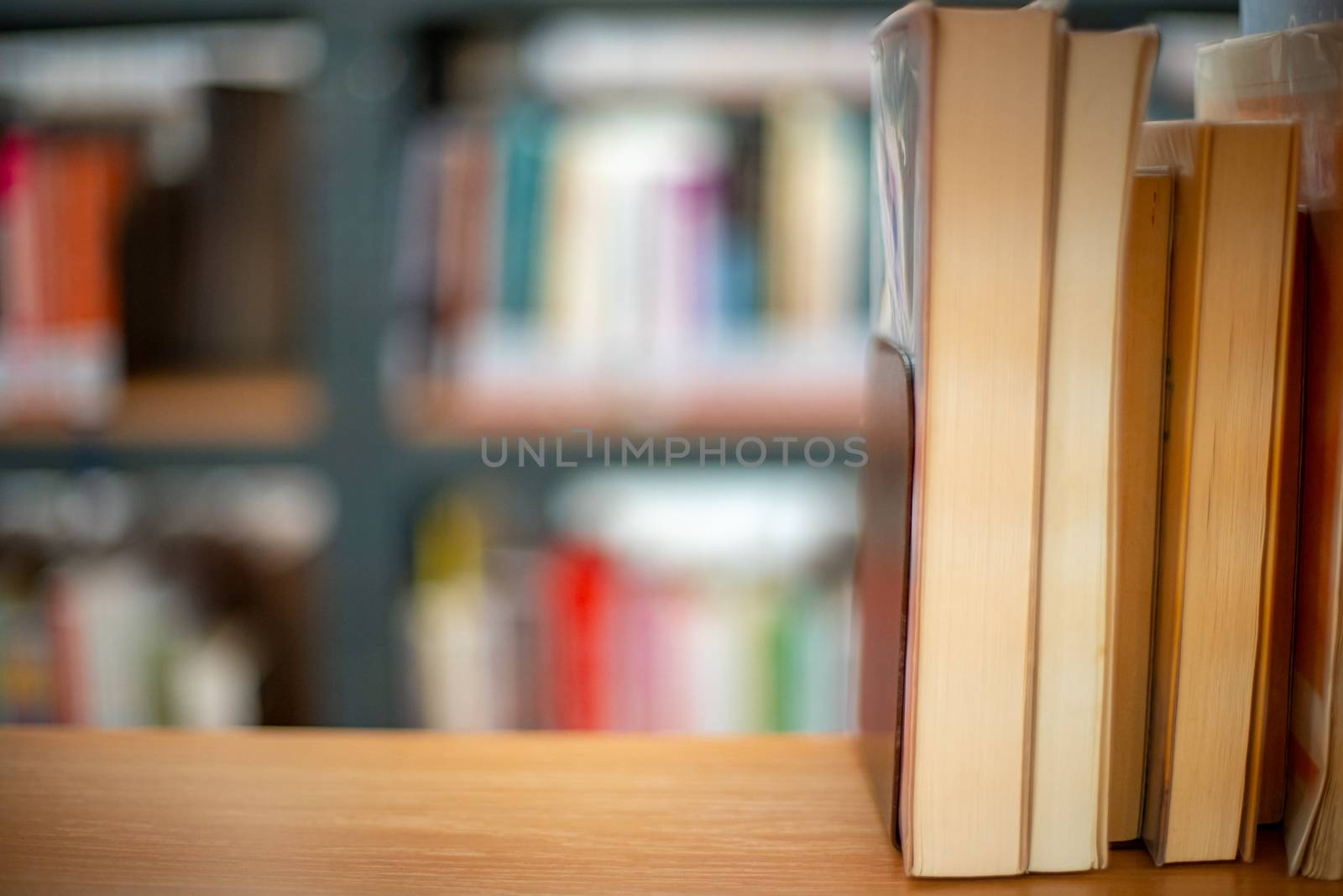 books on a shelf in a public library ready to rent and to study by Edophoto