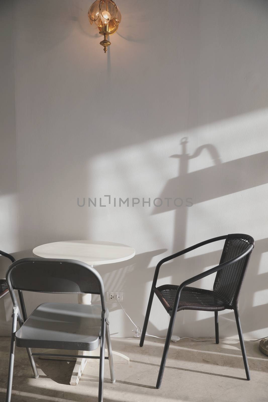 Wooden table and chairs with lamp on wall