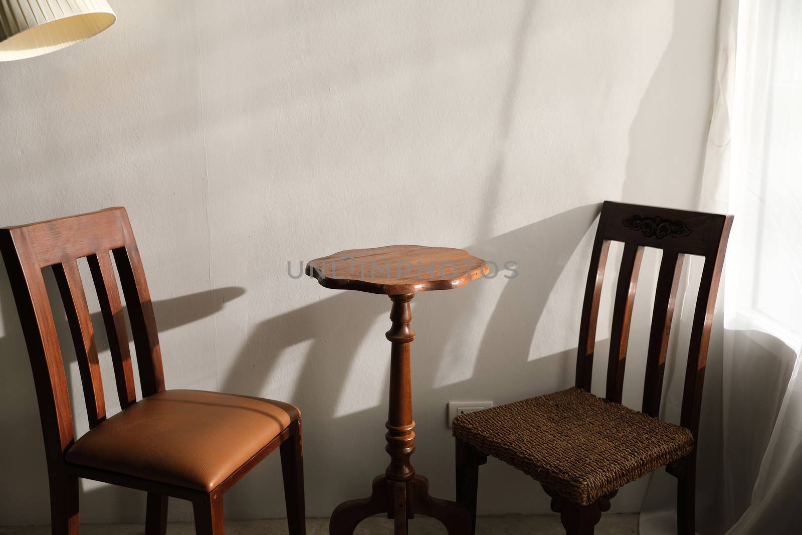 Wooden table and chairs with lamp on wall
