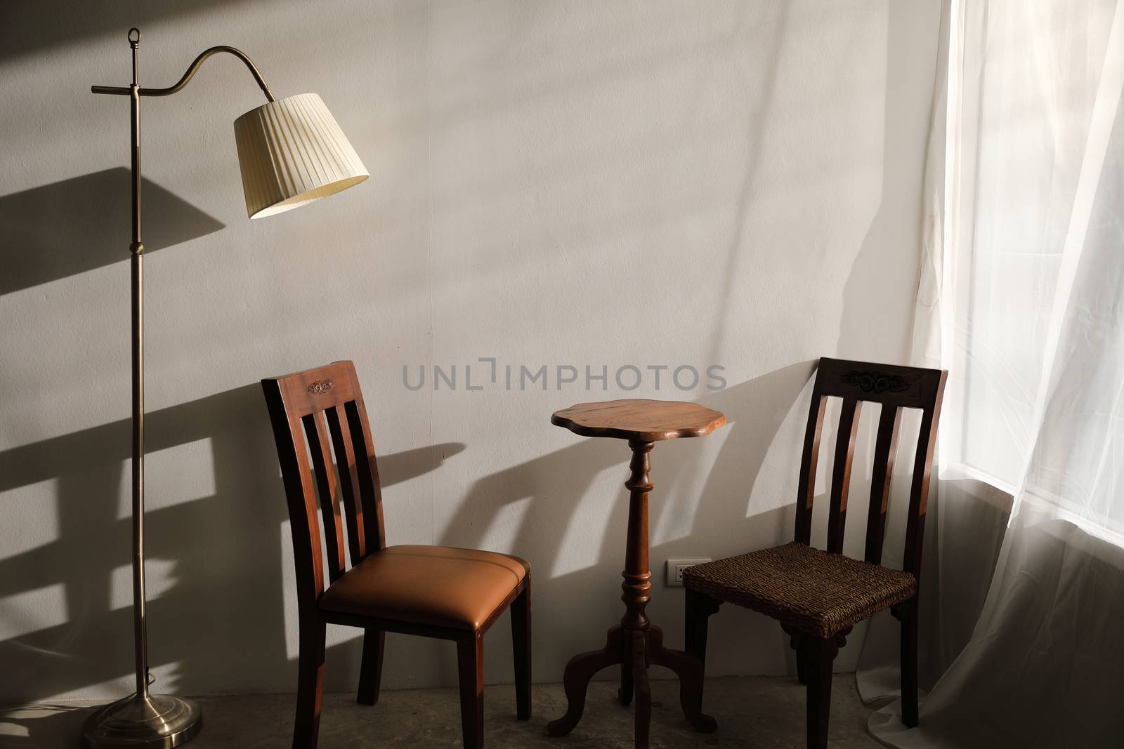 Wooden table and chairs with lamp on wall