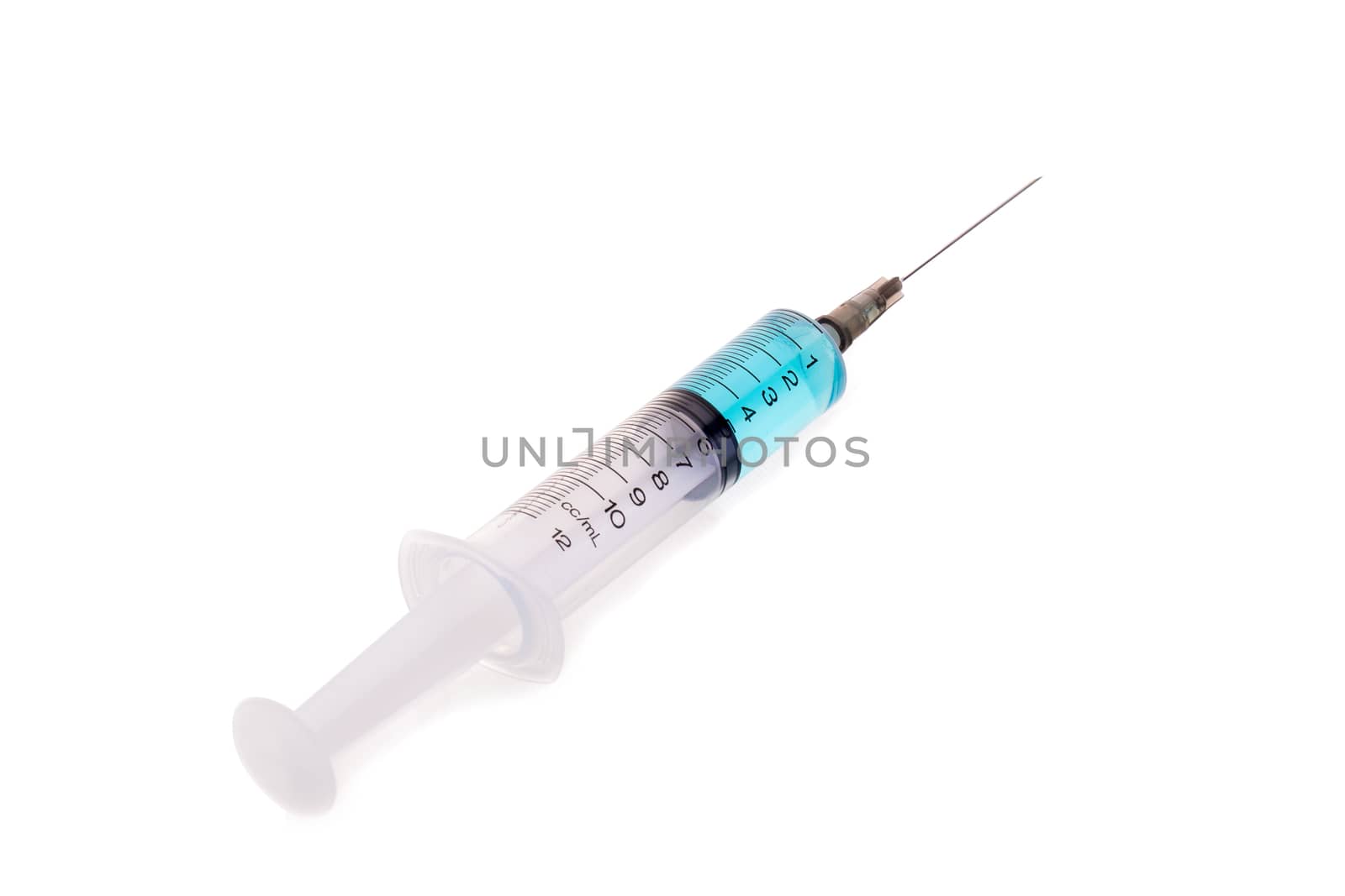 pills and plastic medical syringe on a white background.