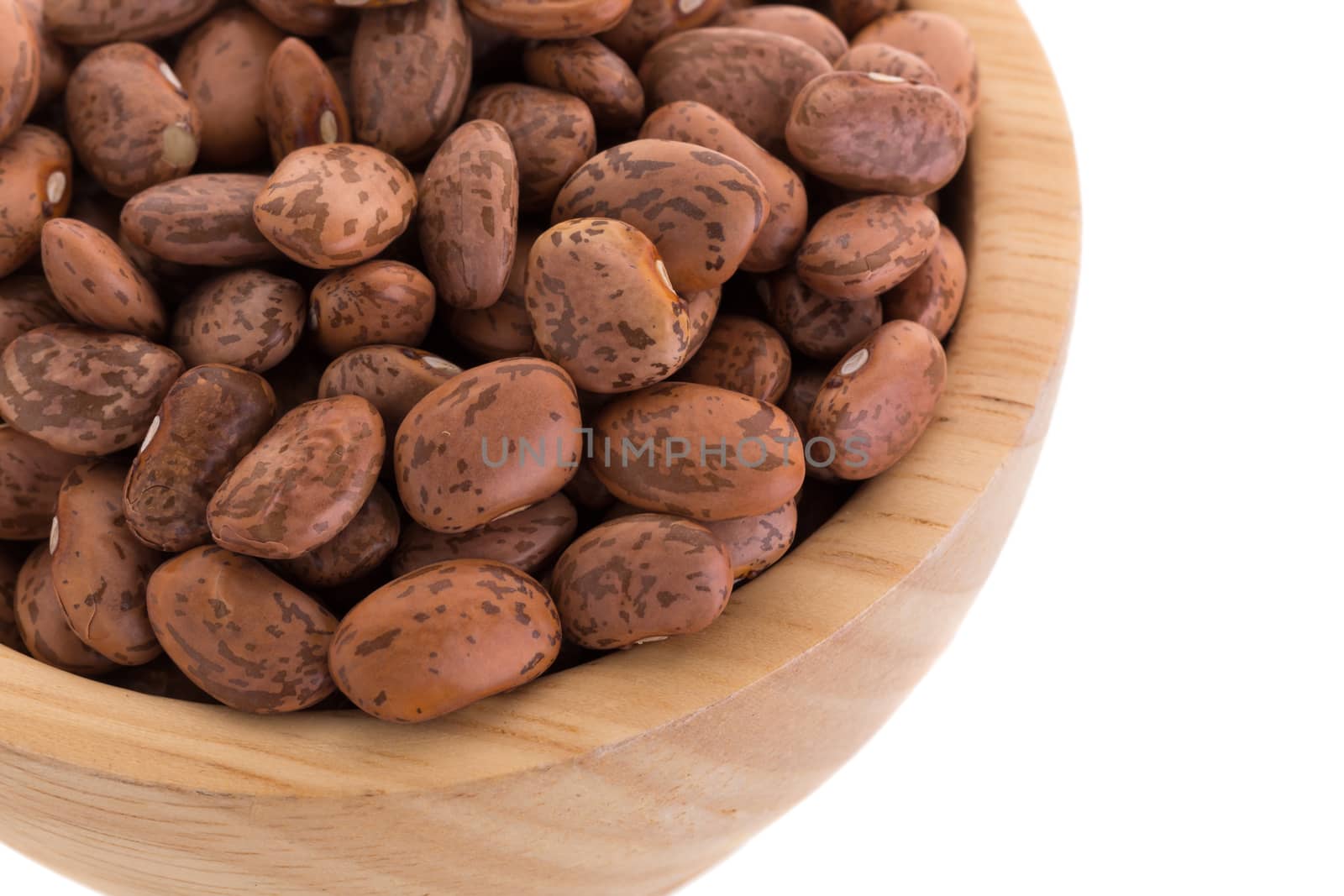 pinto beans  in a wooden bowl isolated on a white background. by kaiskynet