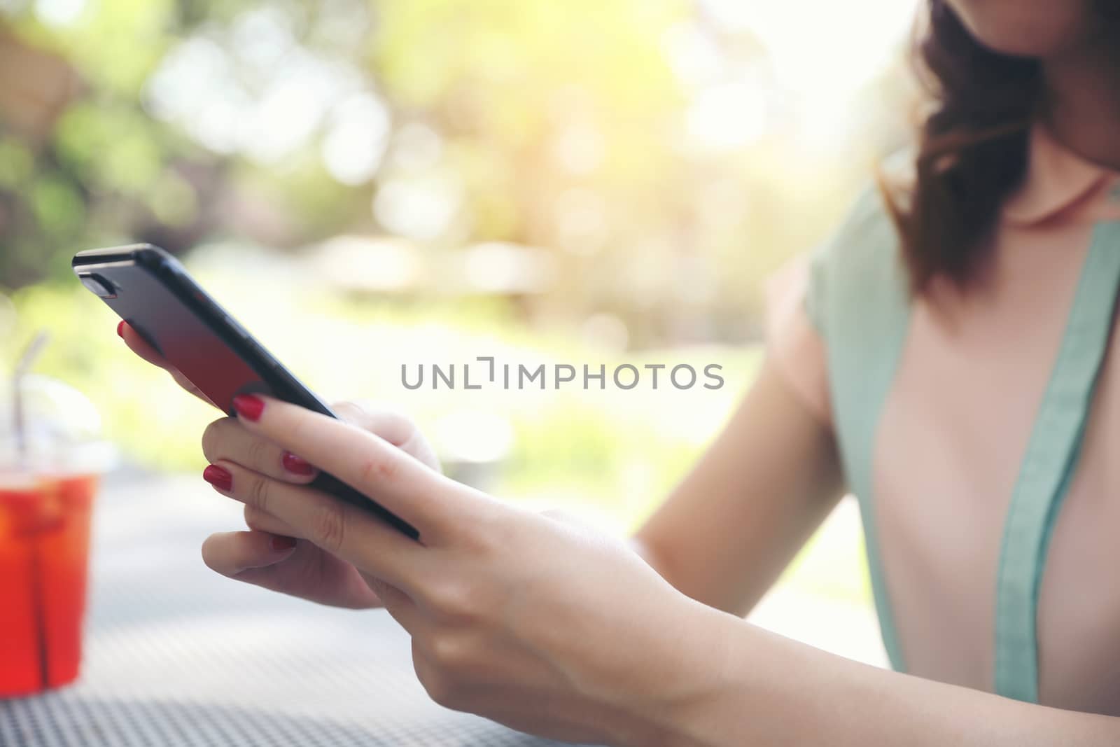 Female hand with smartphone trading stock online in outdoor coffee shop , Business concept