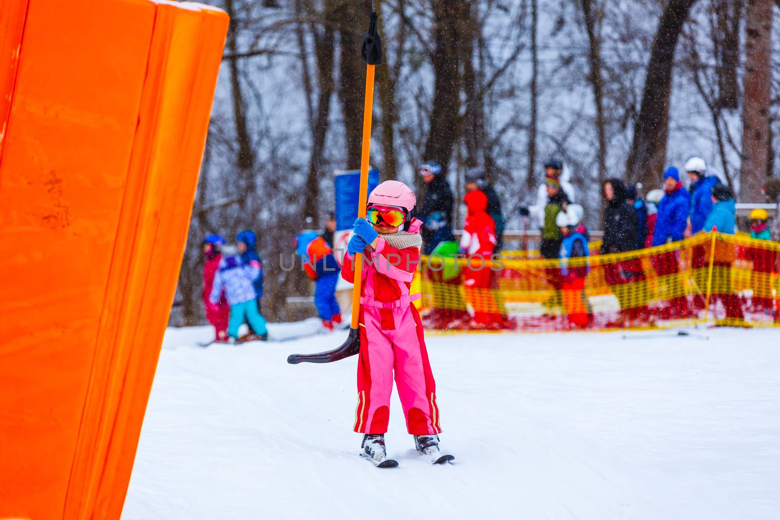 Little girl with ski suit in the ski lift