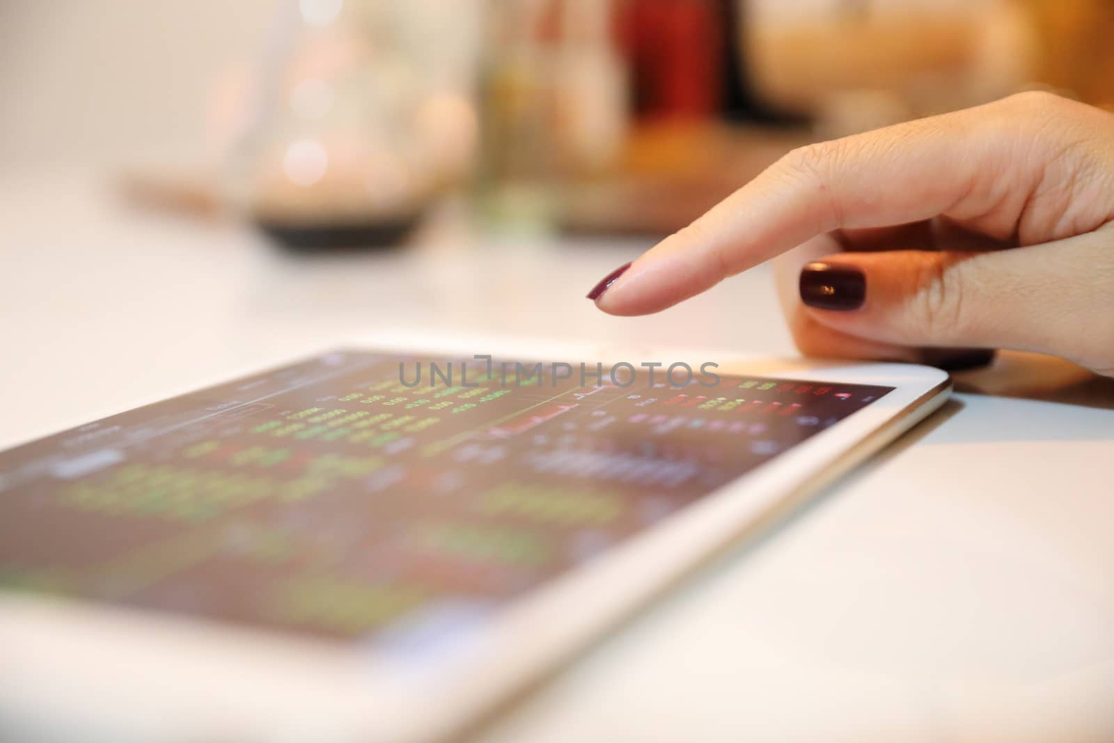 Female hand with tablet trading stock online in coffee shop , Bu by piyato