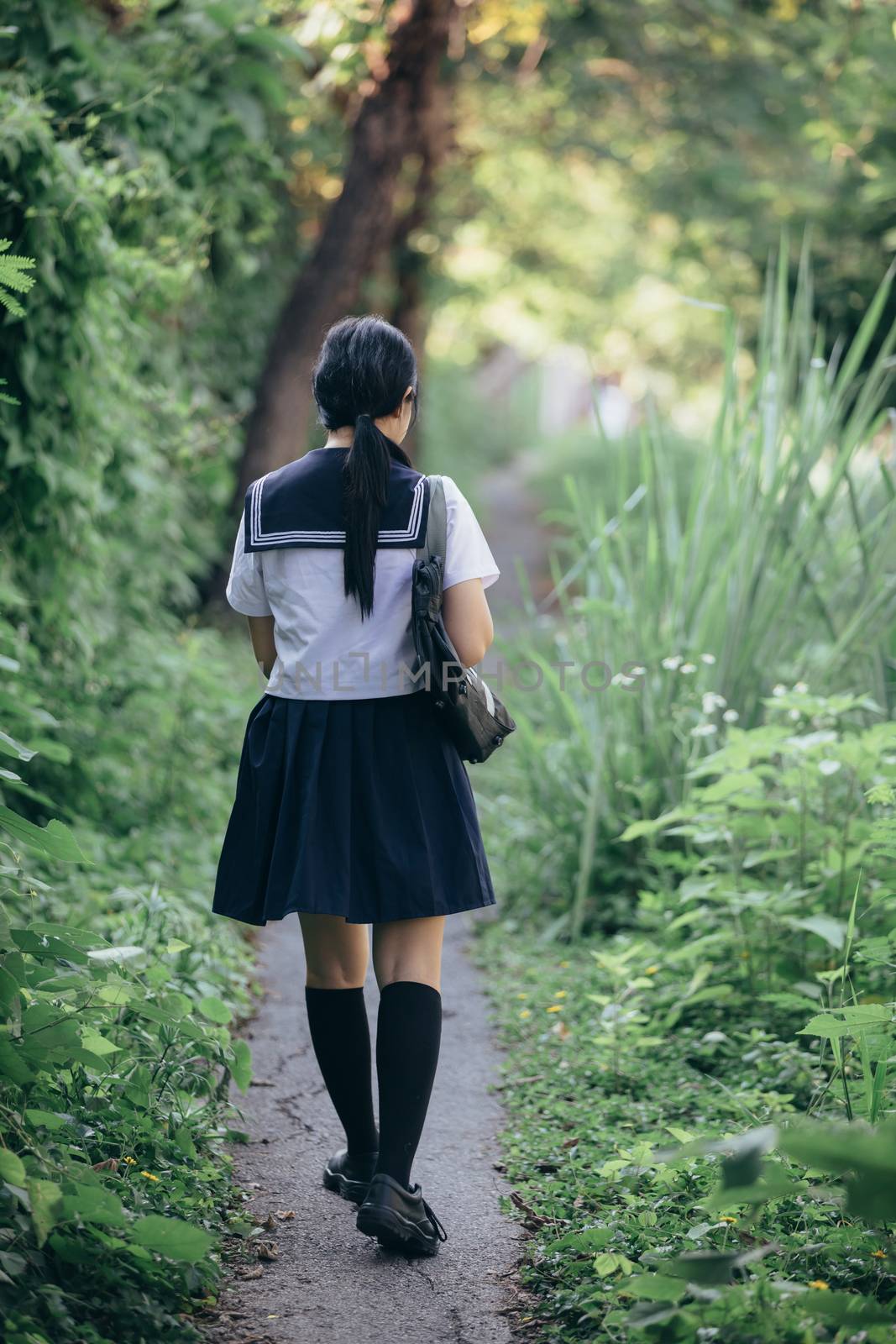 Portrait of asian japanese school girl costume looking at park o by piyato