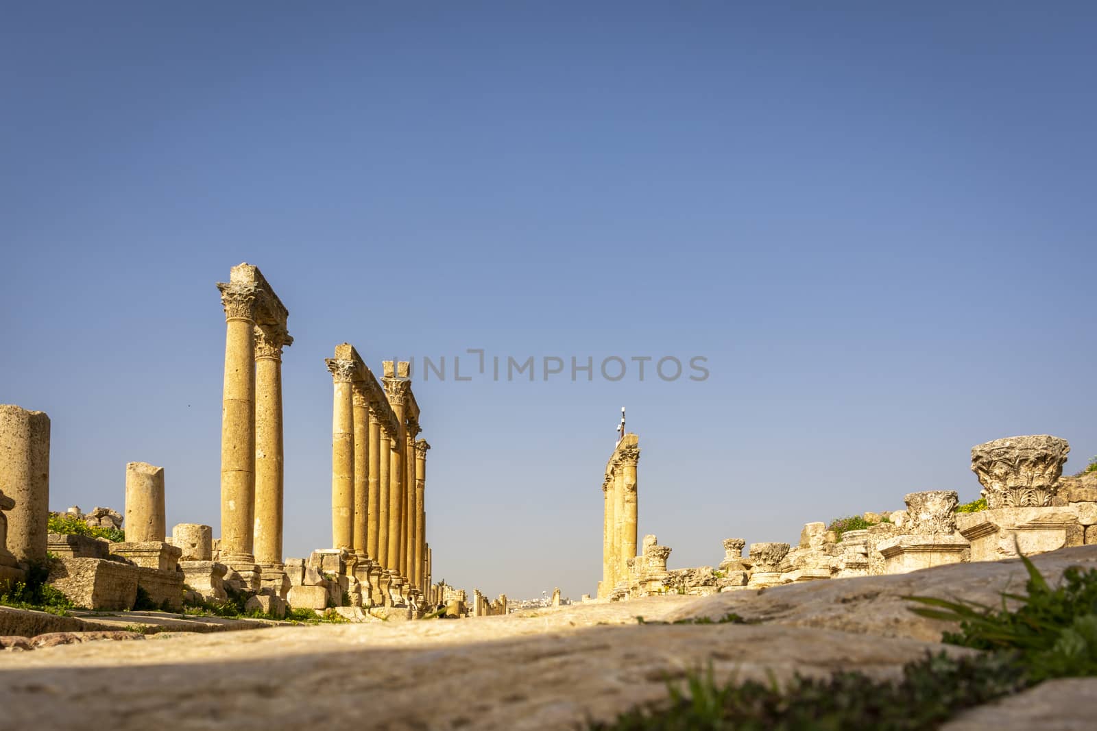 Low angle view of the pillars of the Colonnaded Street at the Roman historical site of Gerasa, Jerash, Jordan by kb79