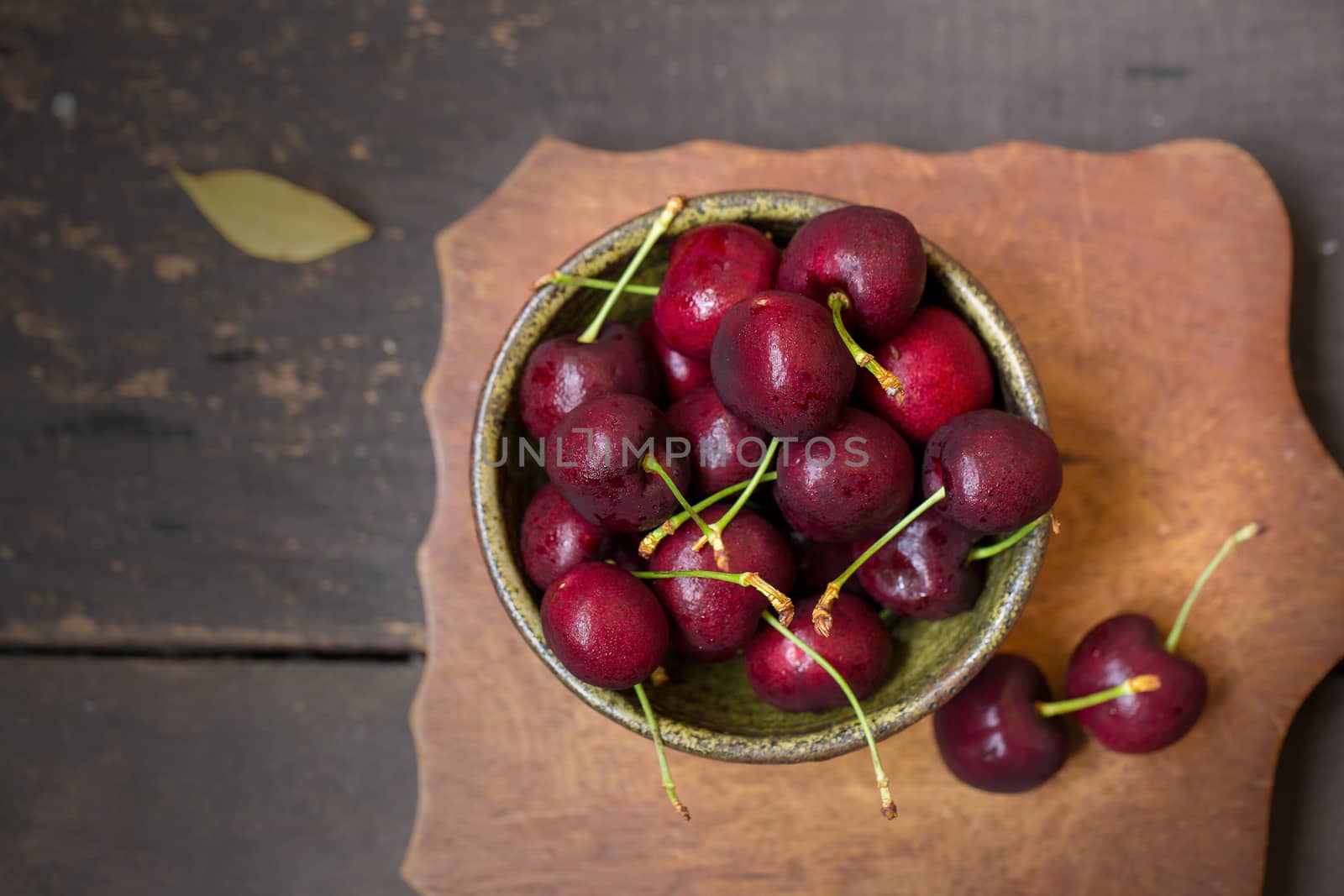 Bowl of Cherries. Red cherries in a bowl on wooden background.
