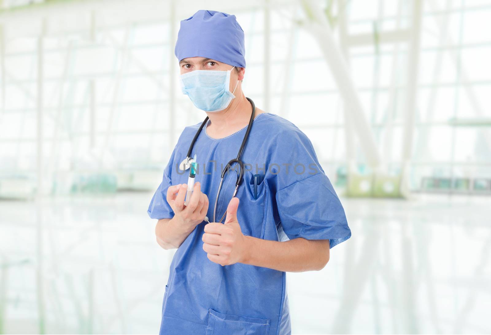 Happy male doctor showing thumbs up, at the hospital