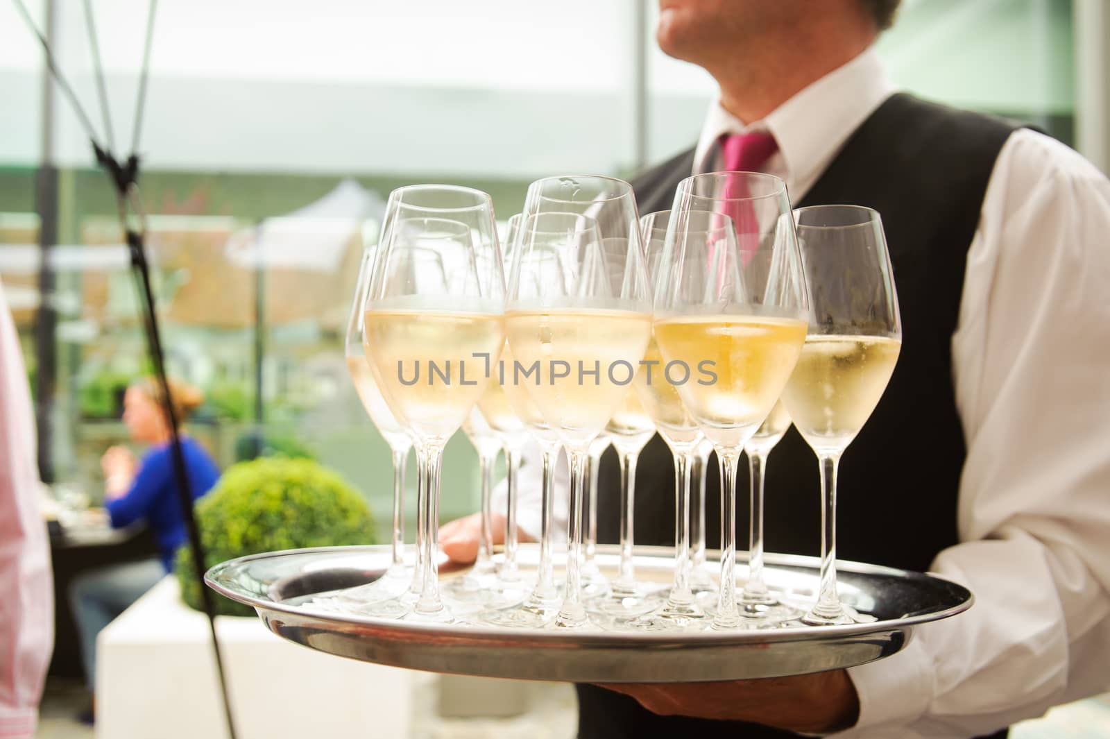 Waiter waiting with a plate full of glasses Champagne
