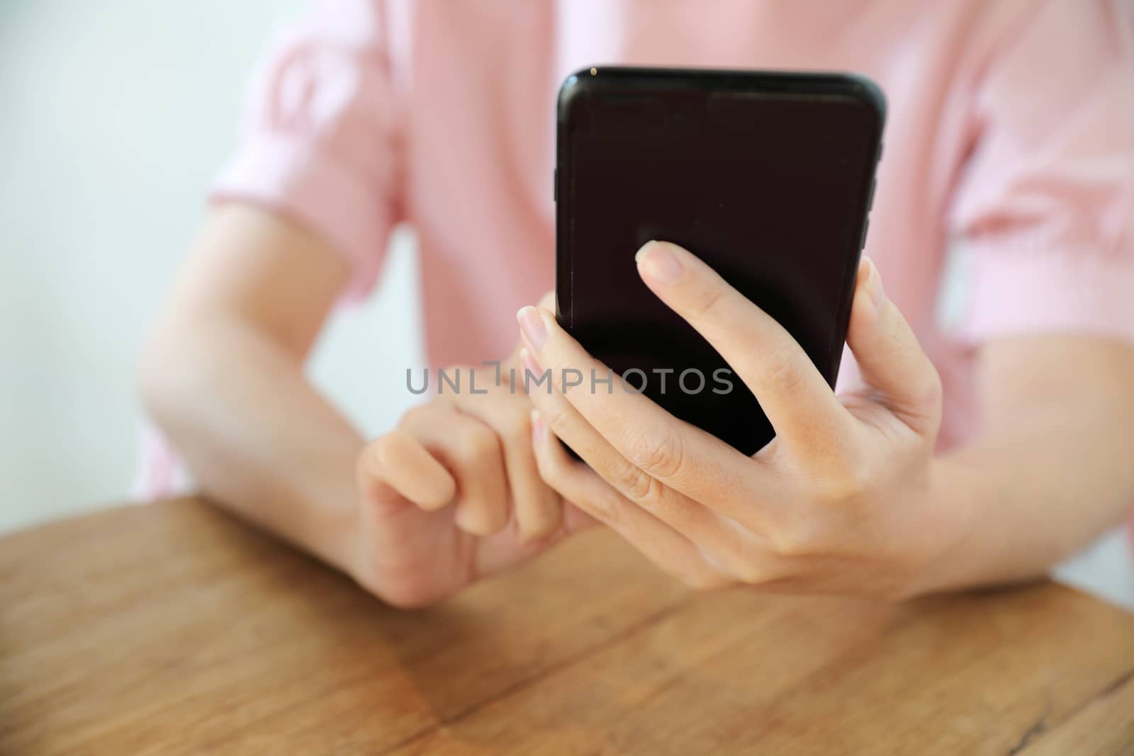 Female hand with smartphone trading stock online in coffee shop , Business concept