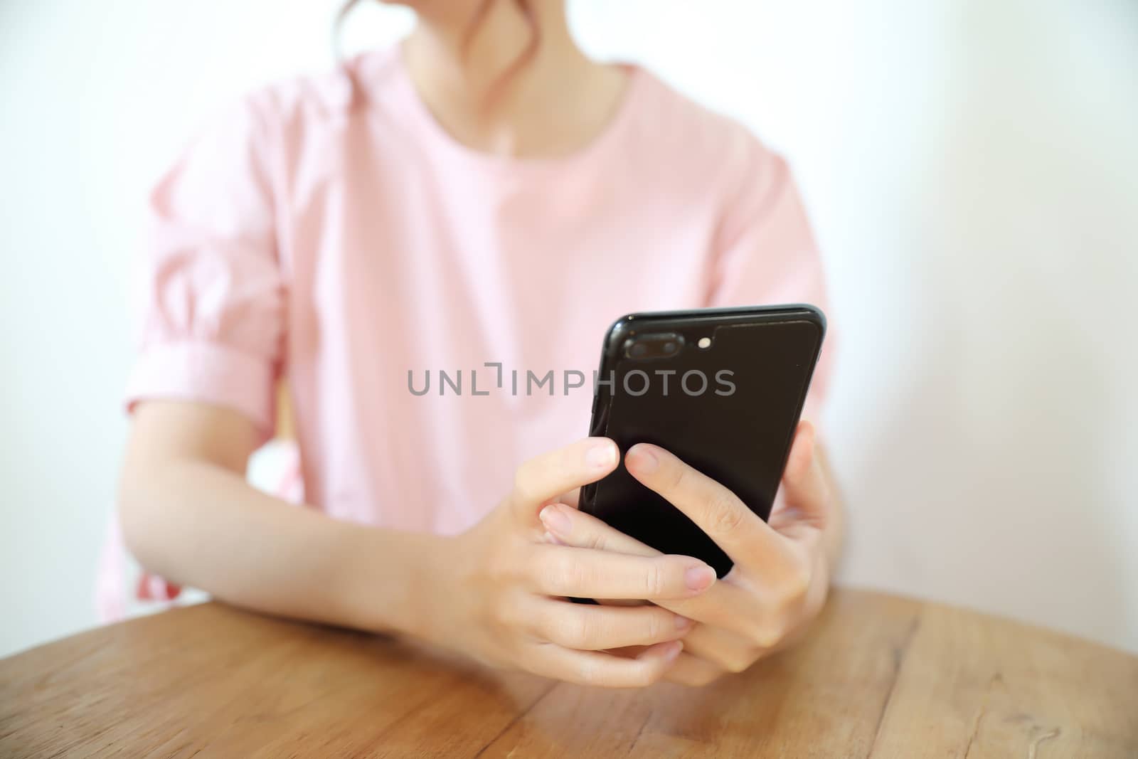 Female hand with smartphone trading stock online in coffee shop  by piyato