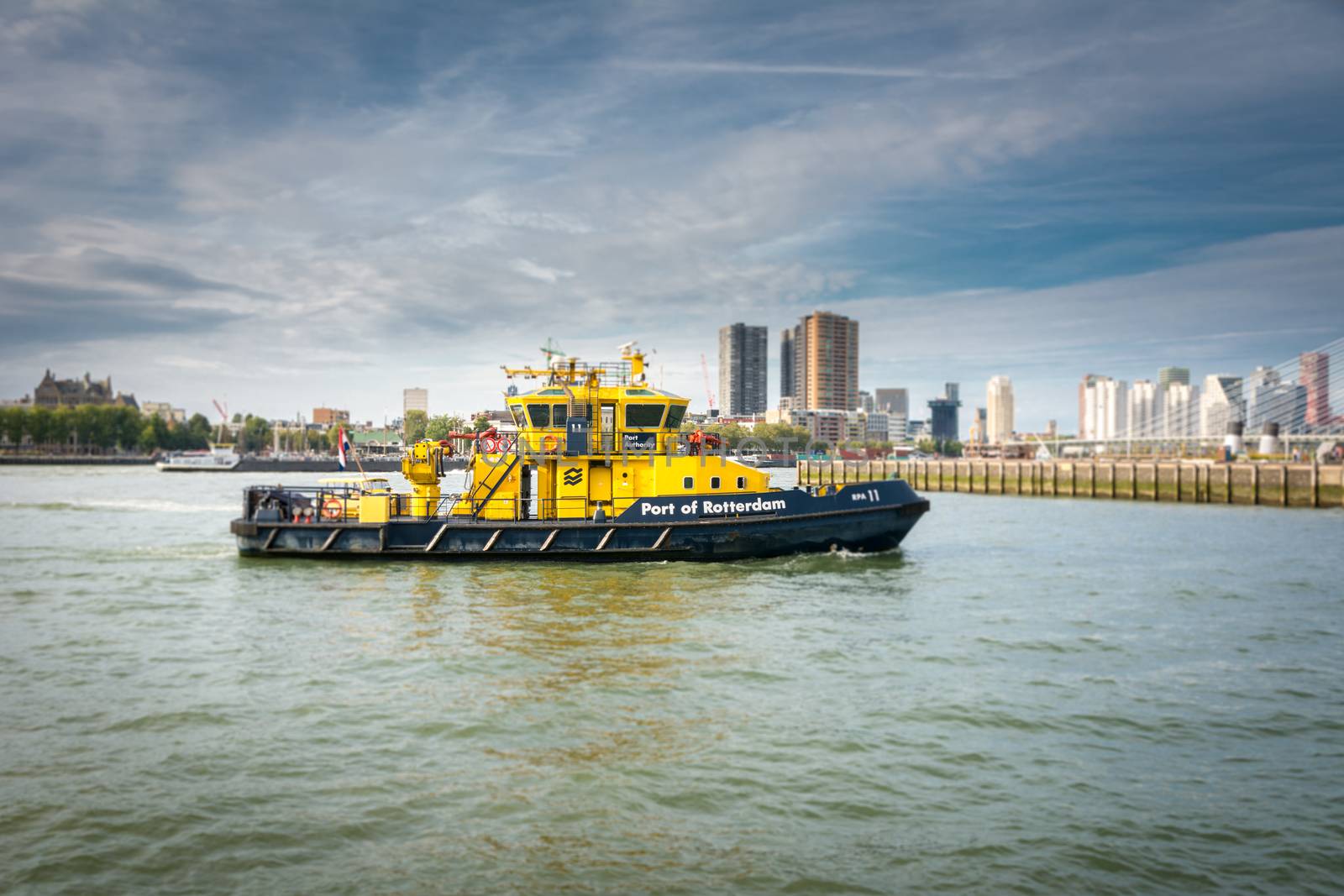 port authority vessel on patrol in the harbor at Wilhelminapier. Skyline of Rotterdam in the background by kb79