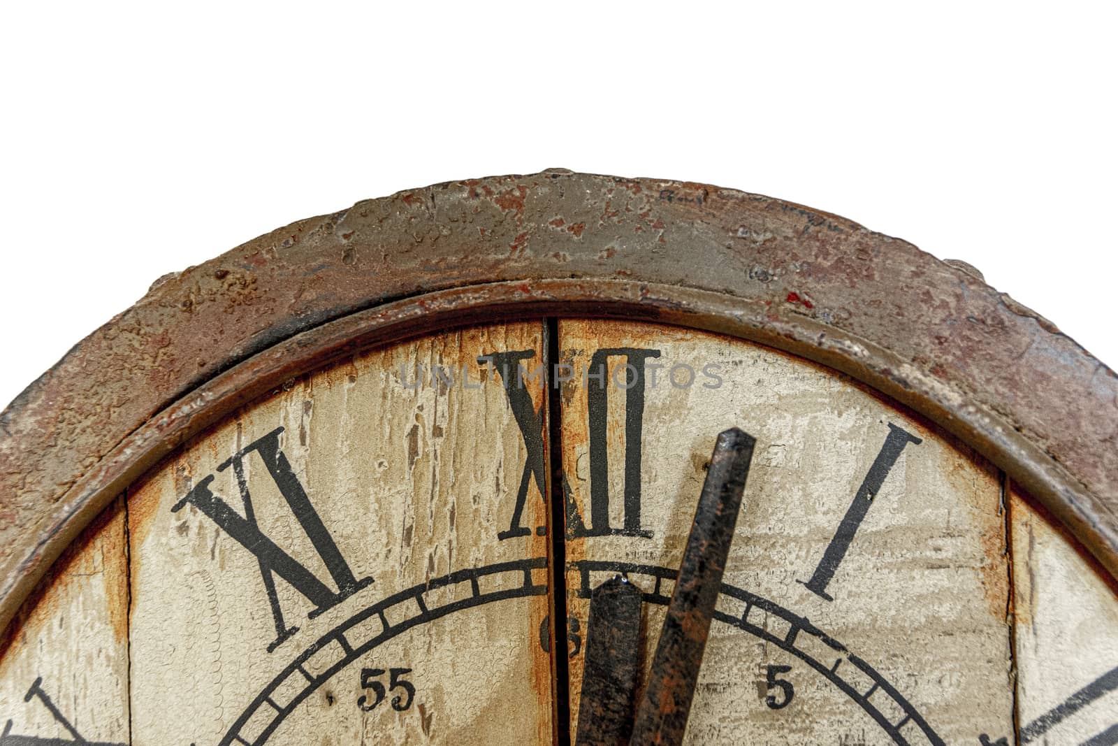 Old vintage and retro analogue clock displaying few minutes after twelve. Worn-out and grunge style with wooden background. Front view.